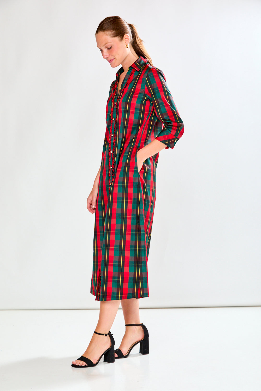 Woman wearing a red and green plaid dress on a white background