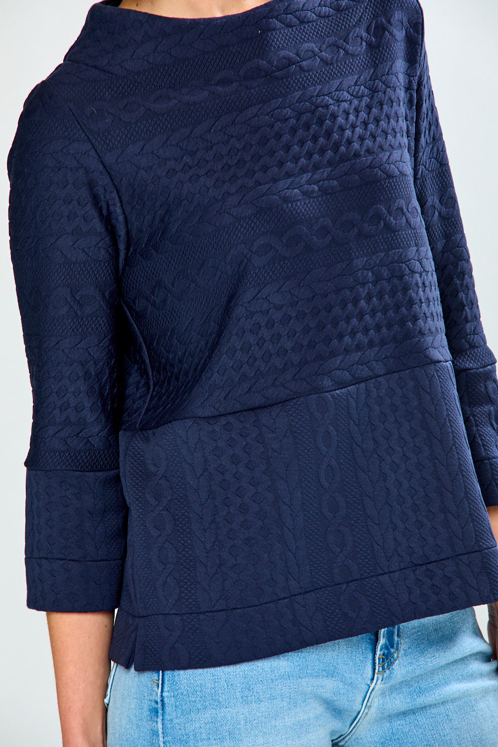 Navy blue textured sweater worn by a person on a white background