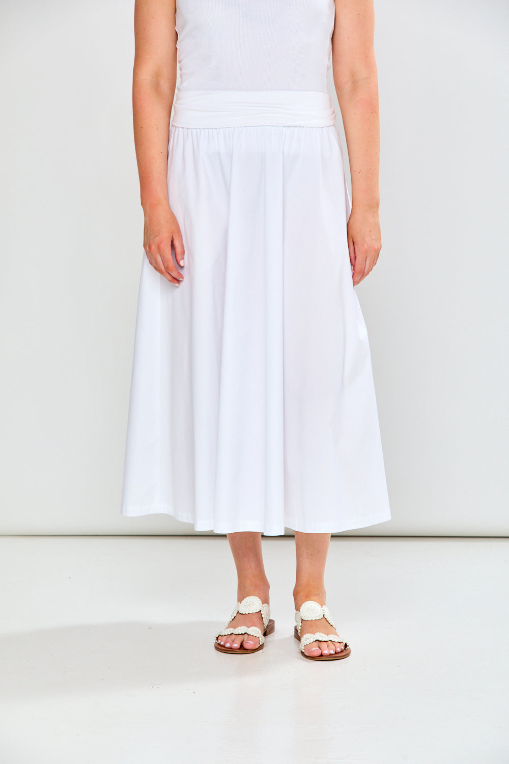 Person wearing a white dress with a plain background