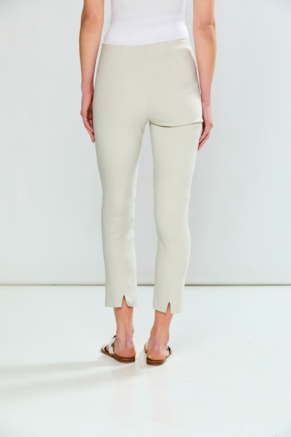 Person wearing light green pants on a white background