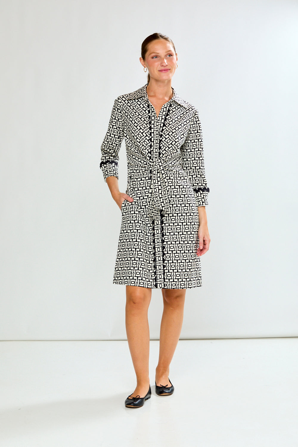 Woman wearing a black and white patterned dress on a white background