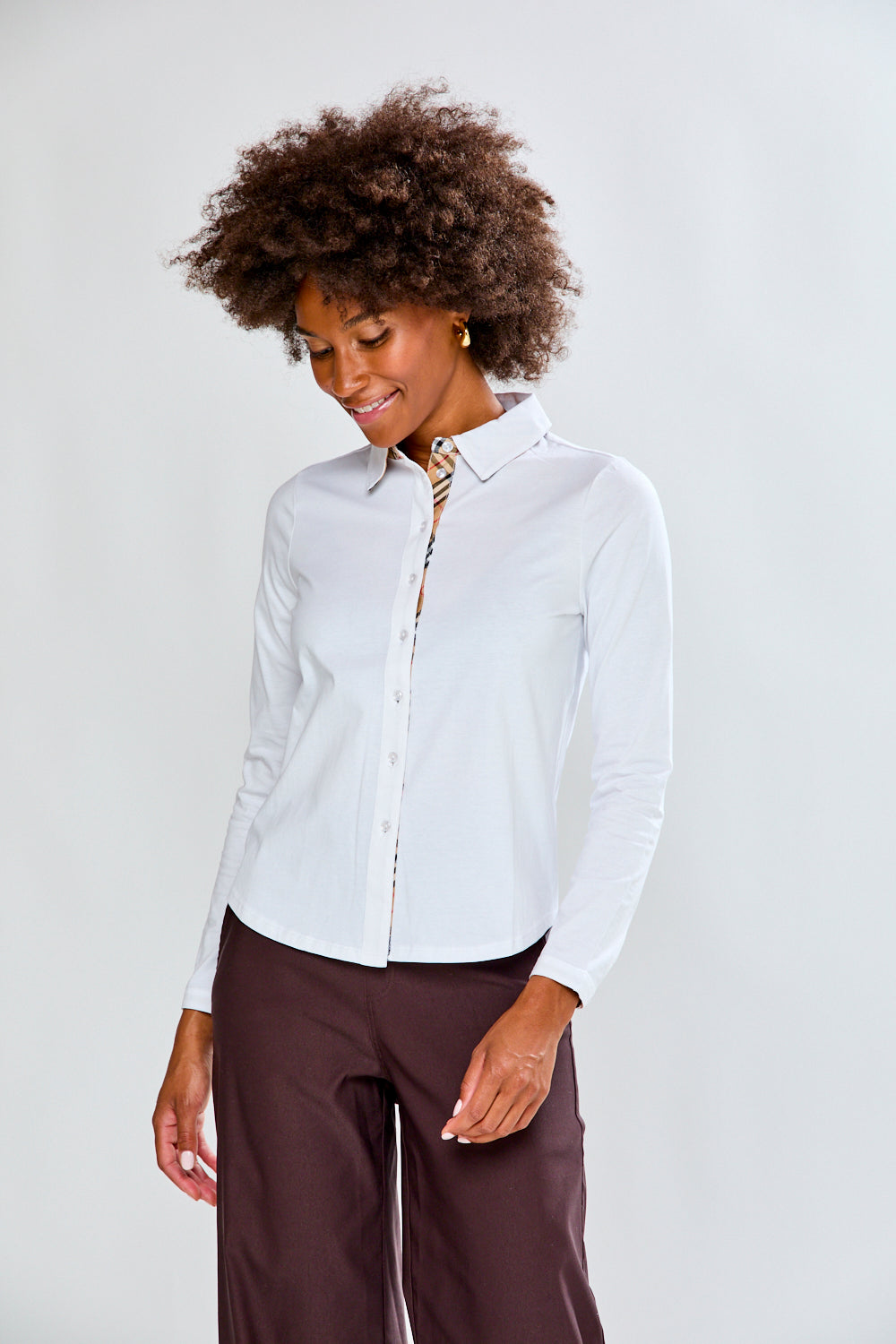 Woman wearing a white shirt and brown pants on a white background