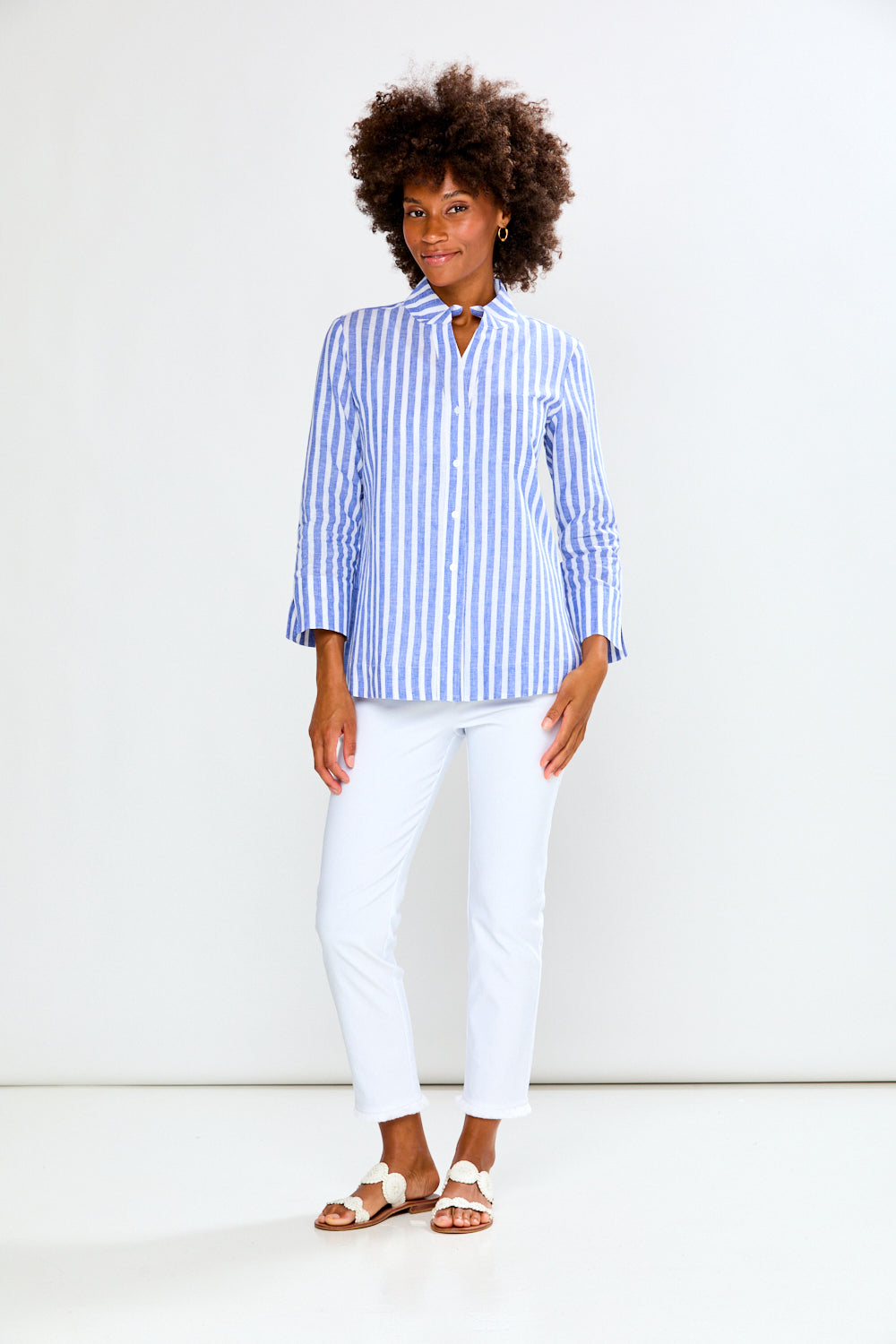 Woman wearing a blue and white striped shirt against a white background
