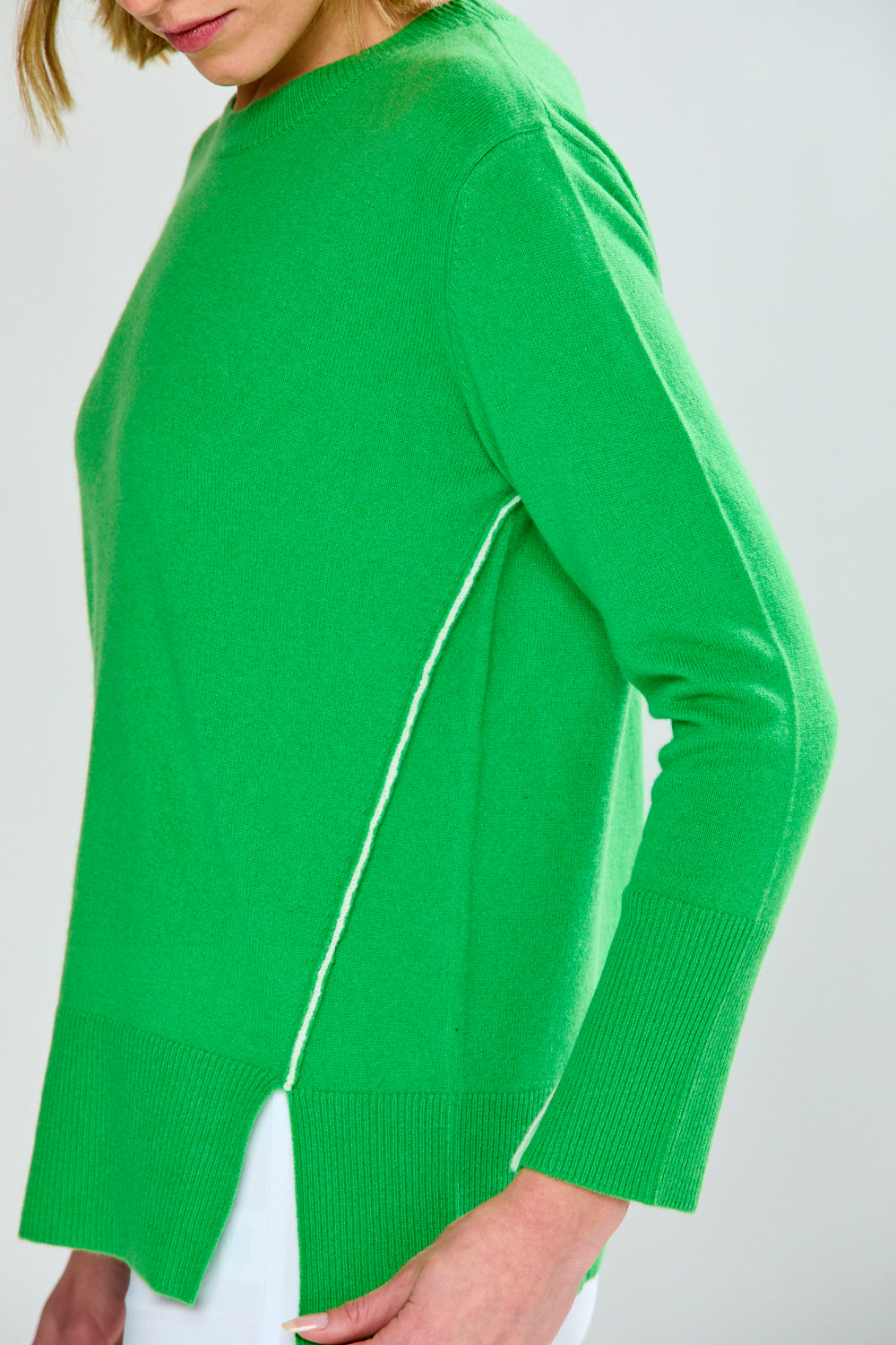 Green sweater with a white zipper on a plain background