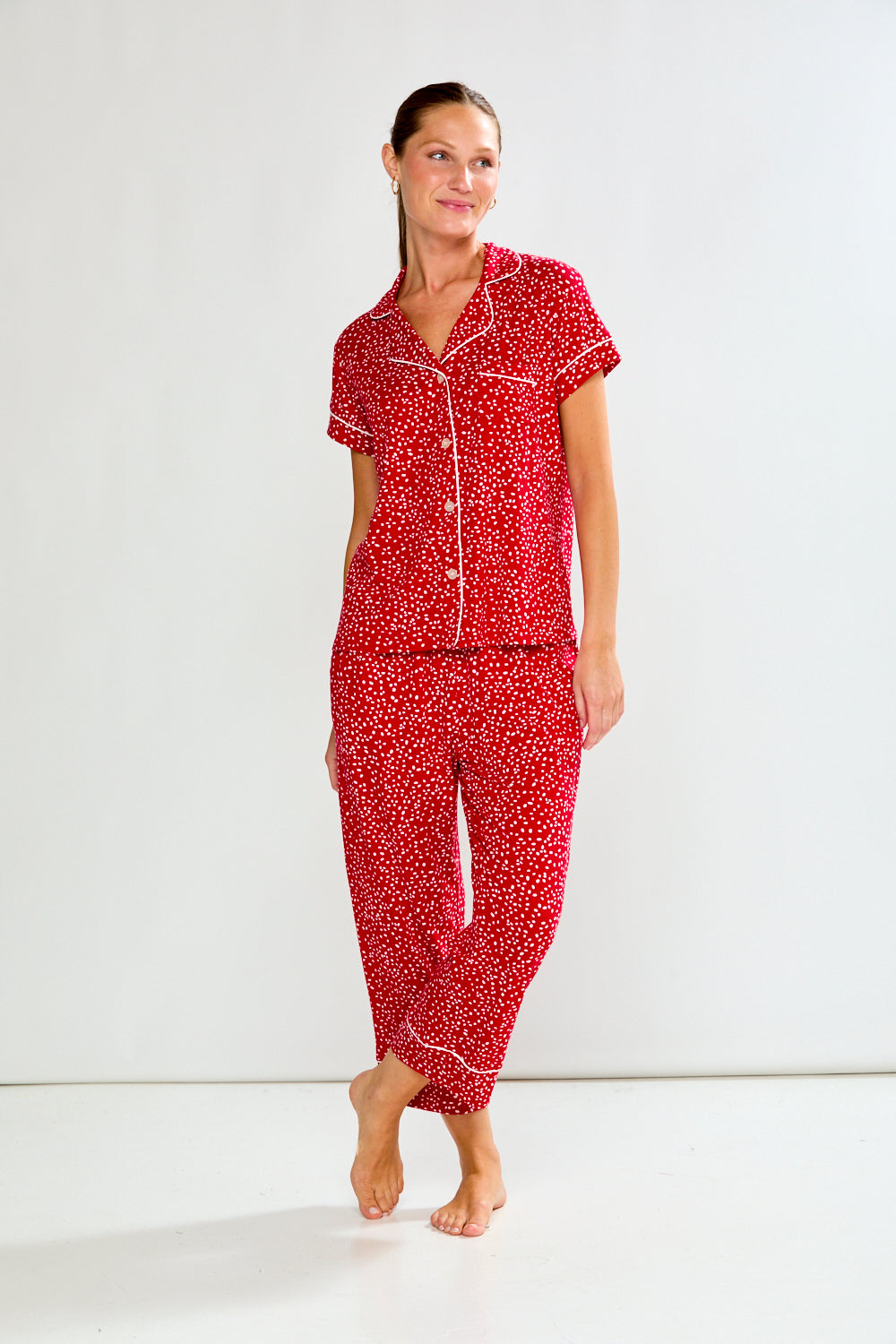 Woman wearing a red patterned pajama set on a white background