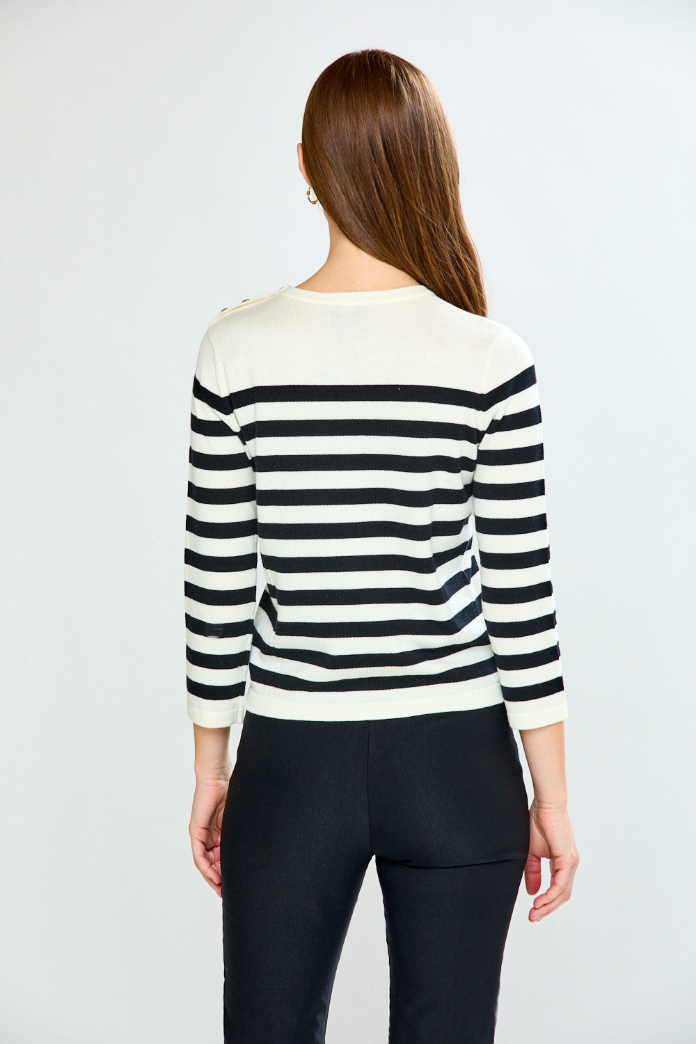 Woman wearing a black and white striped sweater on a plain background