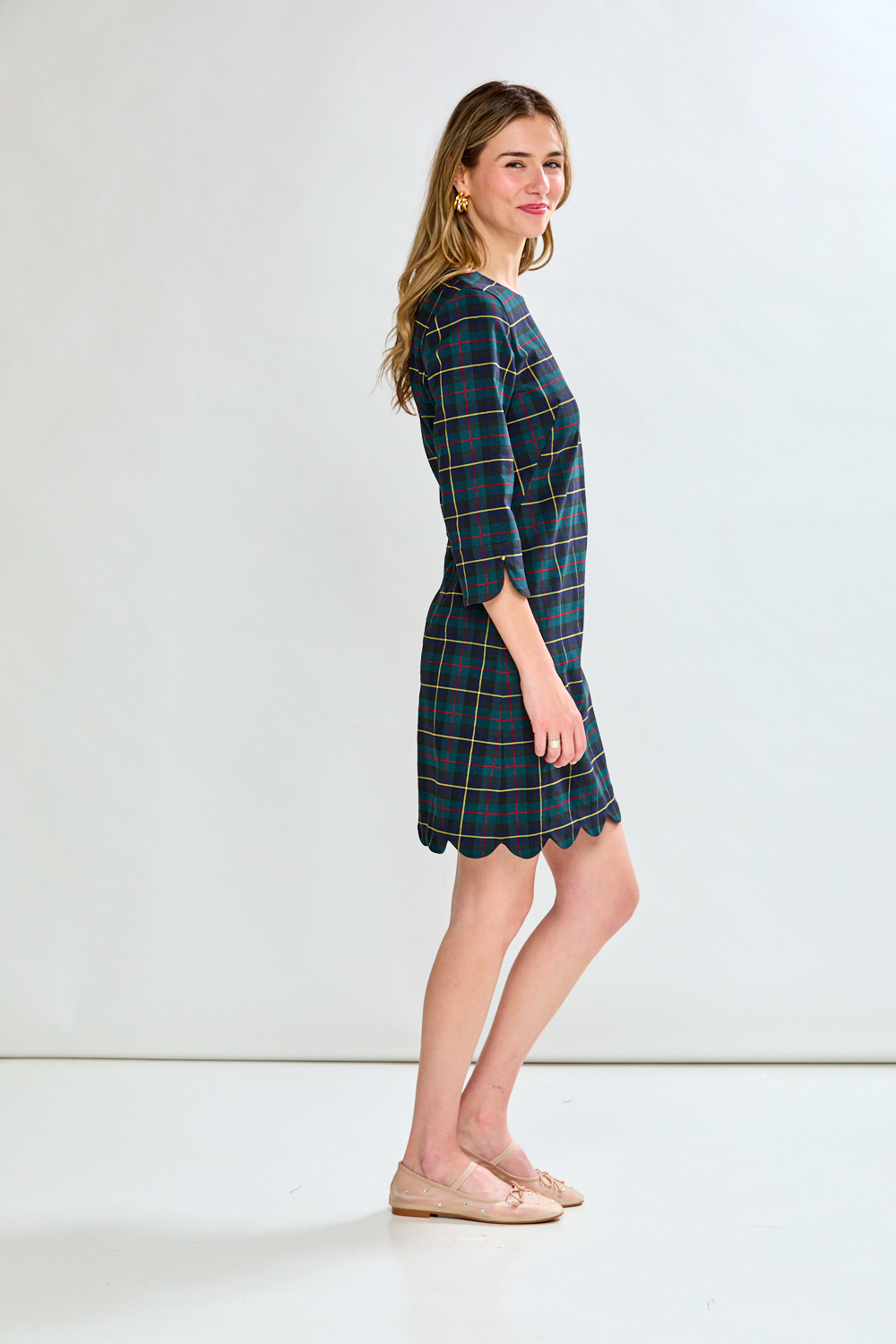 Woman wearing a blue plaid dress on a white background