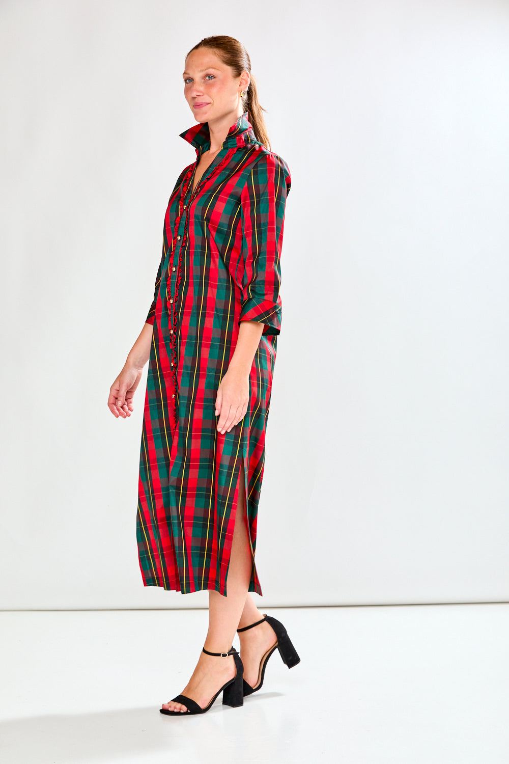 Woman wearing a red and green plaid dress on a white background