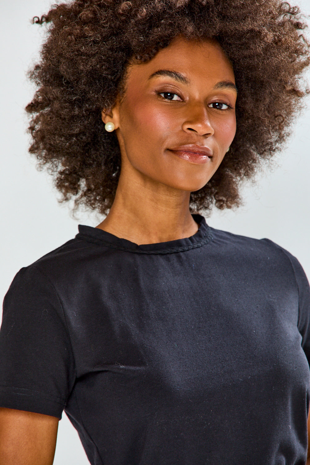 Woman wearing a black t-shirt against a plain background
