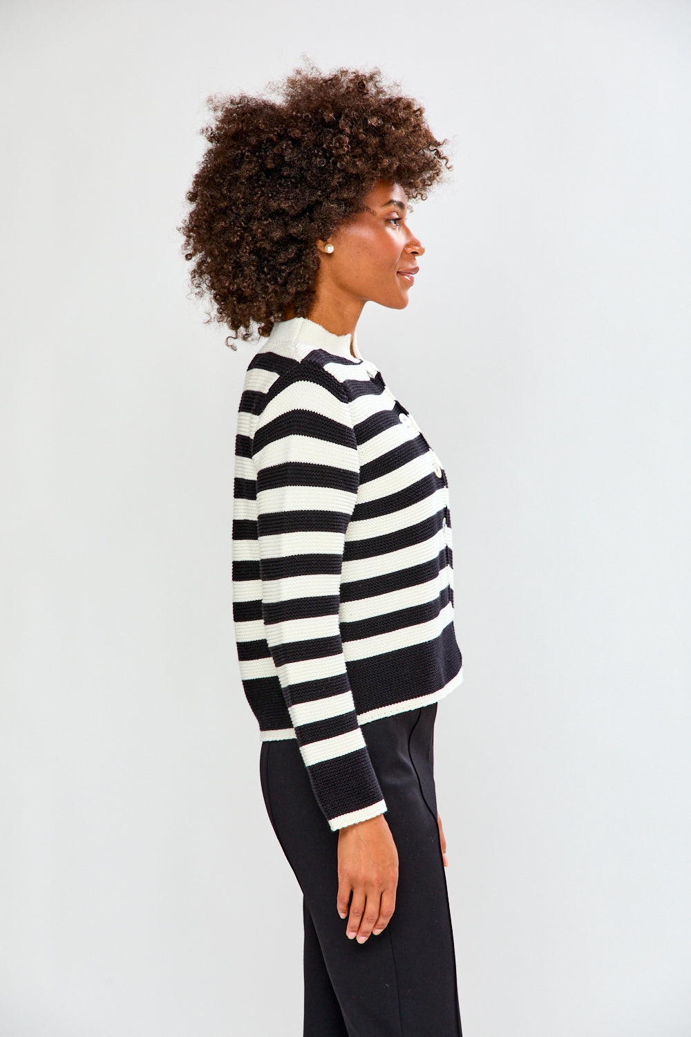 Woman wearing a black and white striped sweater against a white background