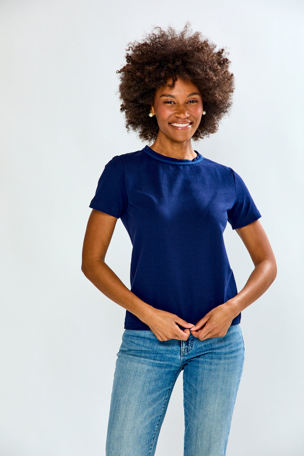 Woman wearing a blue t-shirt and jeans on a white background
