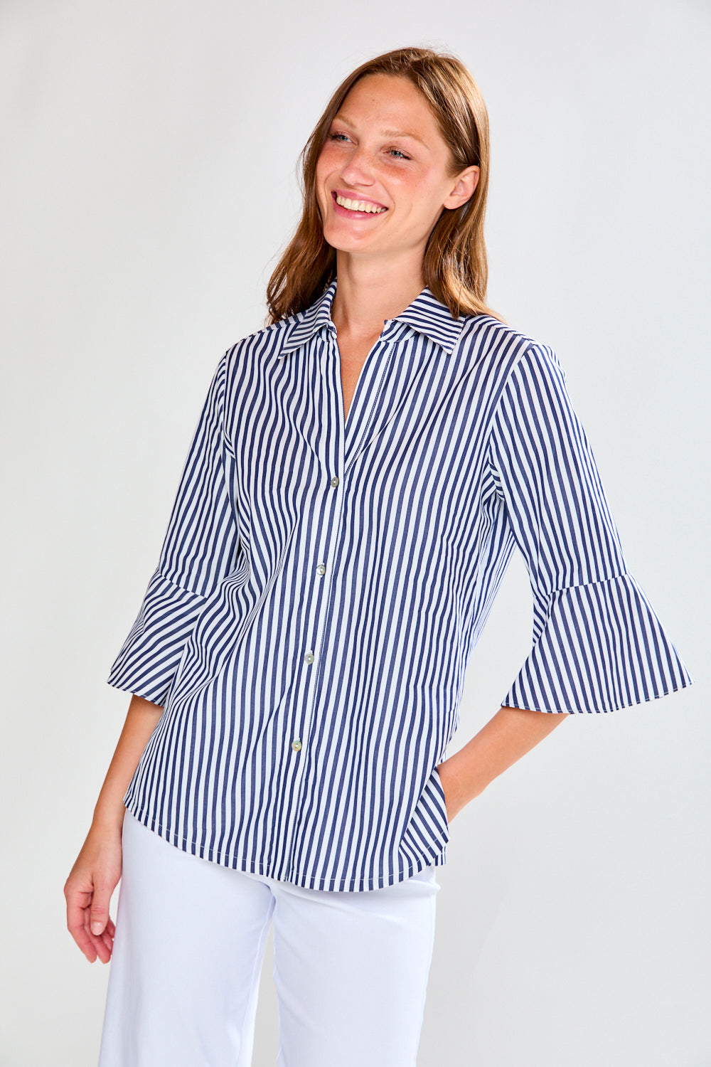 Woman wearing a blue and white striped shirt against a plain background