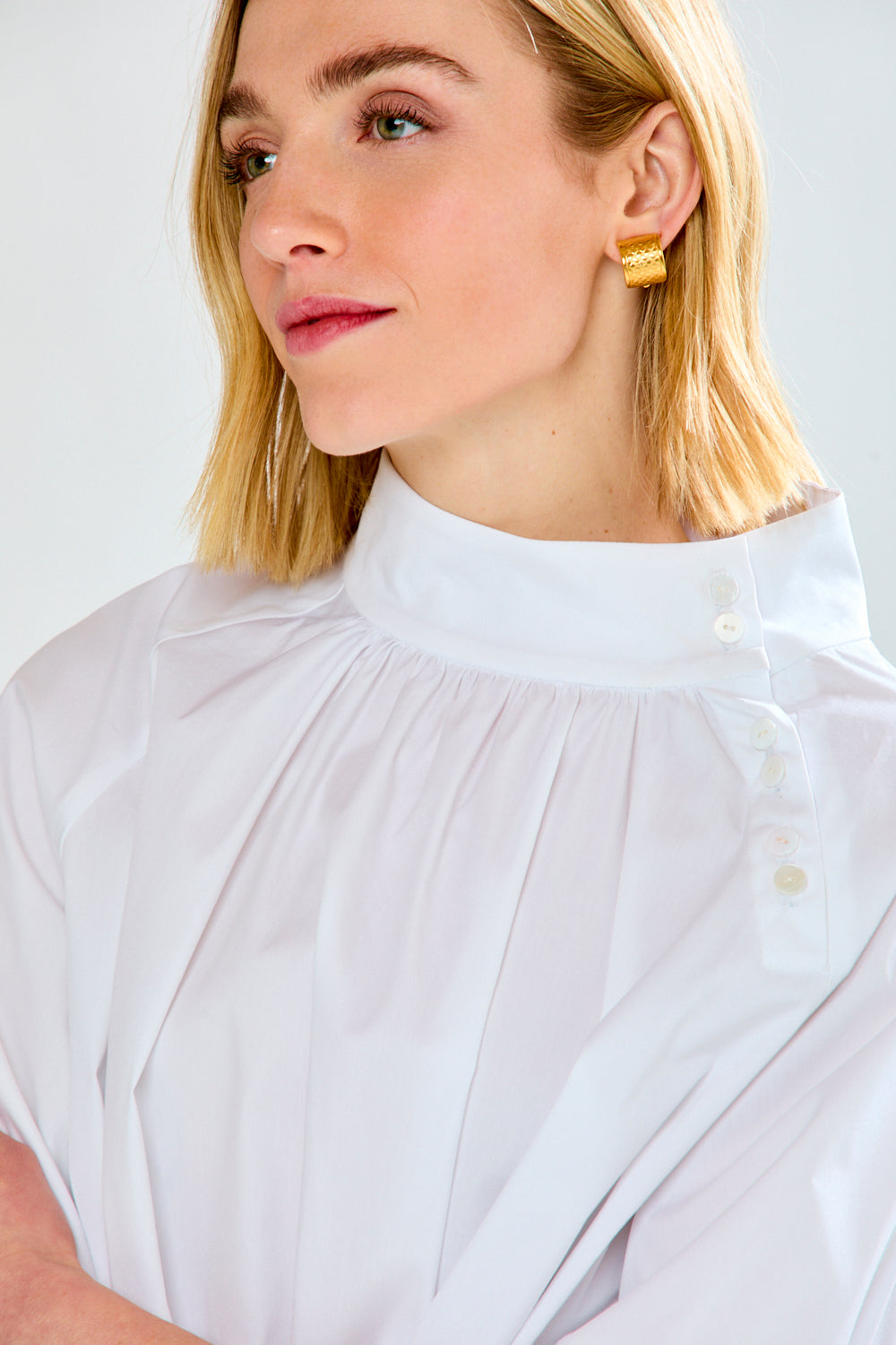 Woman wearing a white blouse with a plain background