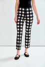 A model wearing black and cream checkered cropped pants with a black top and black flats, shown from the waist down against a white studio background.