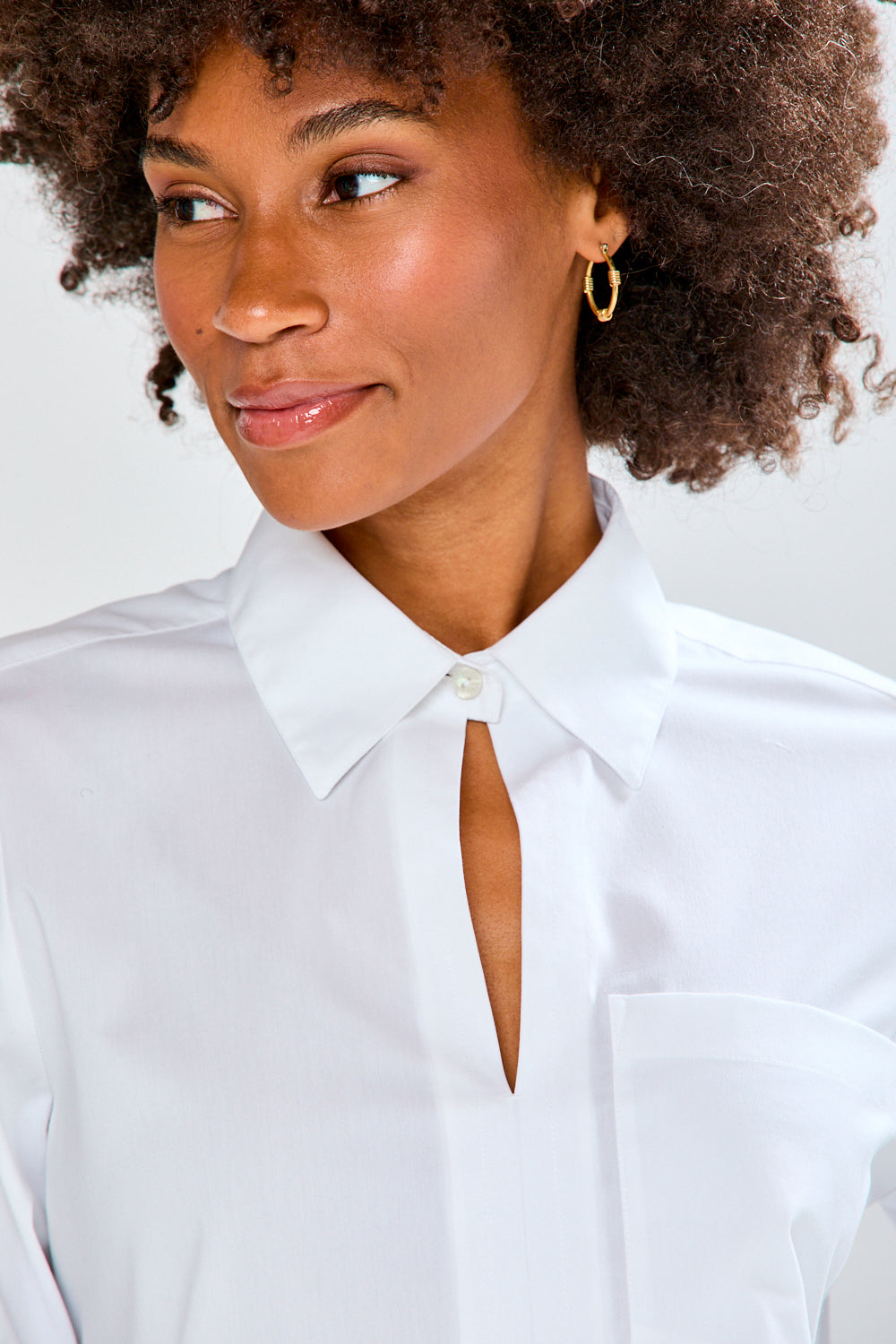 Woman wearing a white blouse with a plain background