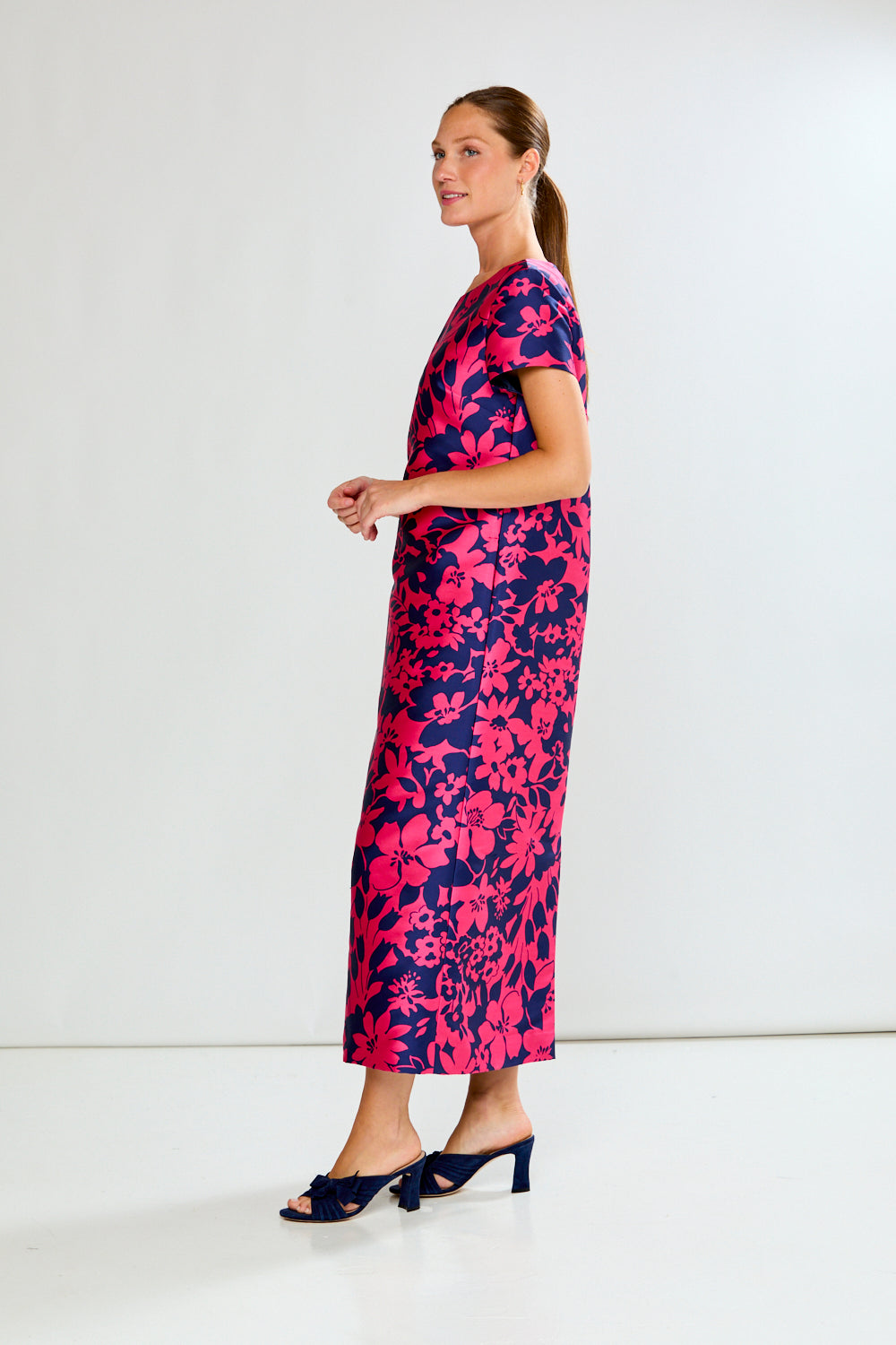 Woman wearing a pink and blue floral dress on a white background