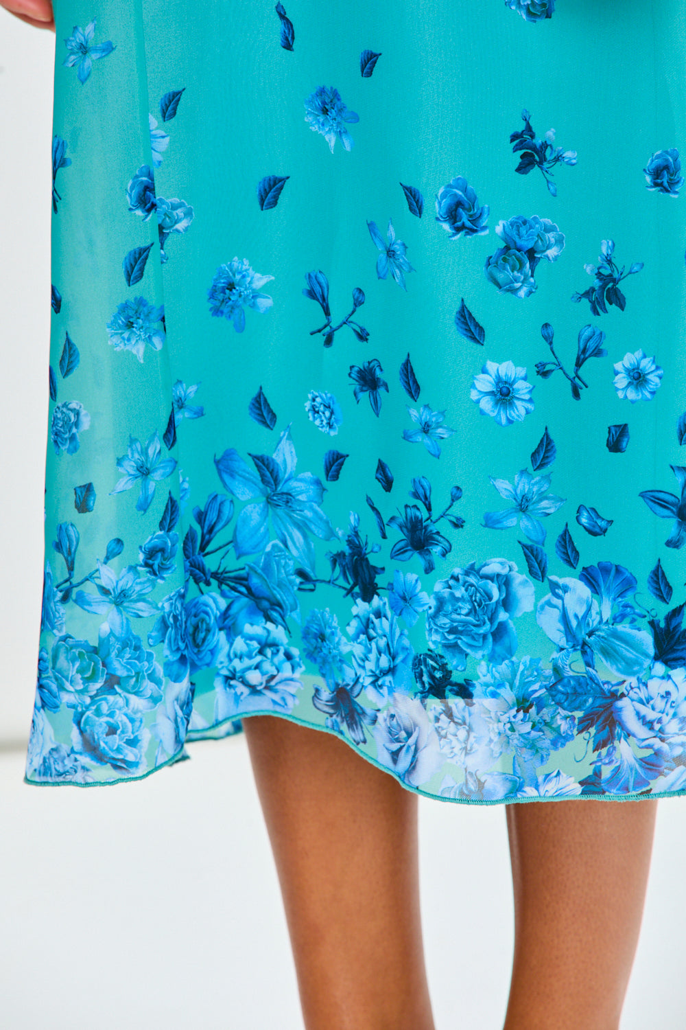 Woman wearing a blue floral dress against a white background