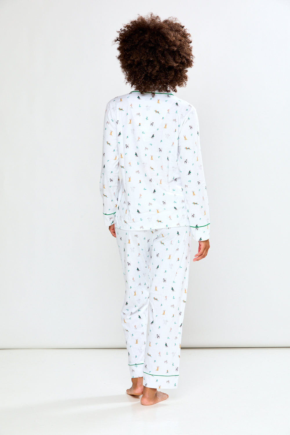 Woman wearing a white pajama set with a dog pattern on a white background