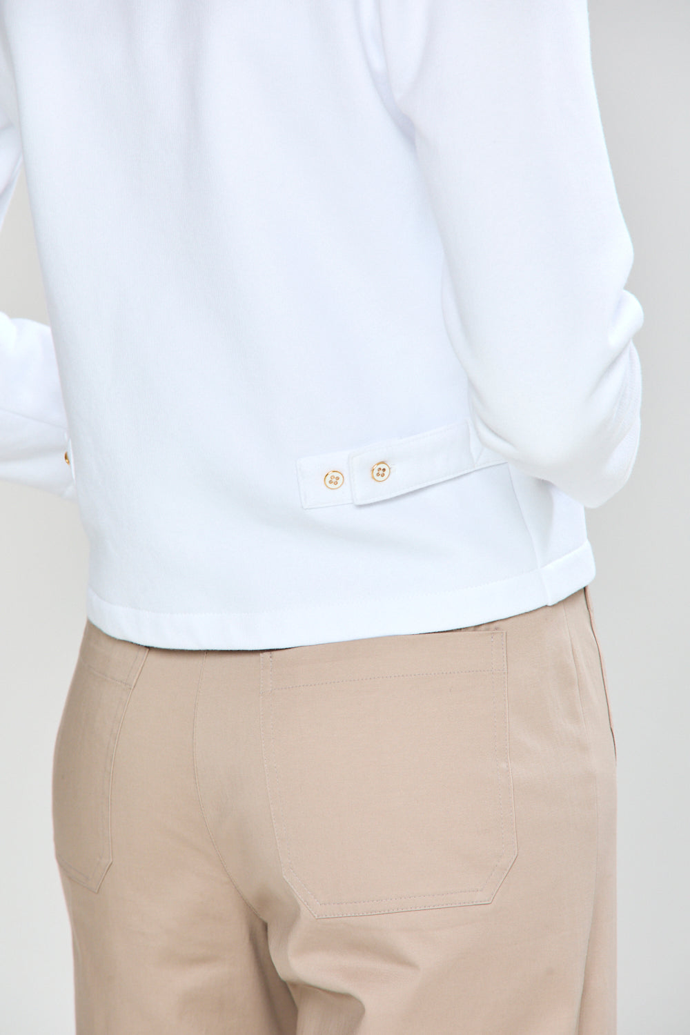 White shirt and beige pants on a plain background