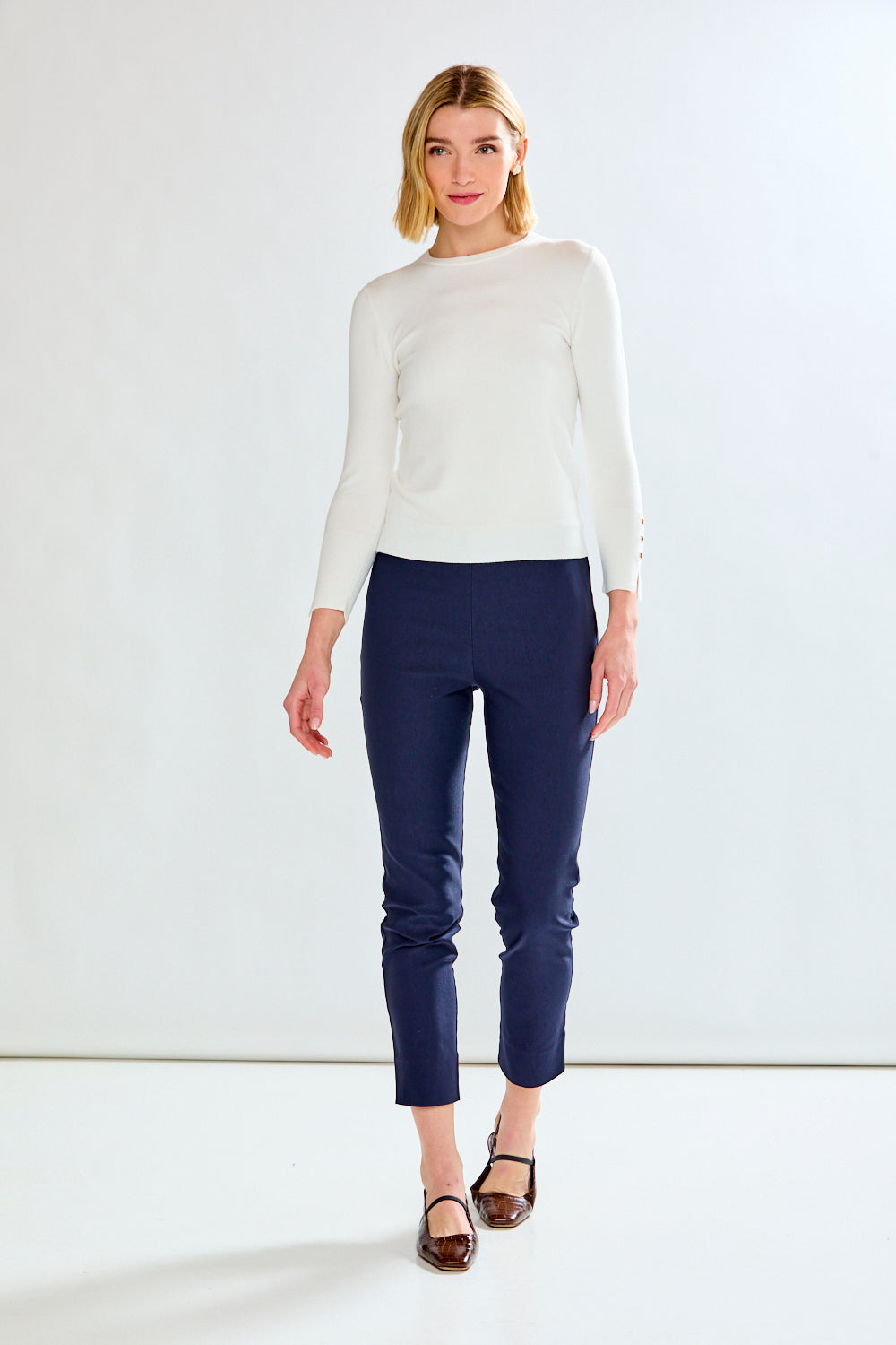 woman in white sweater and navy pants