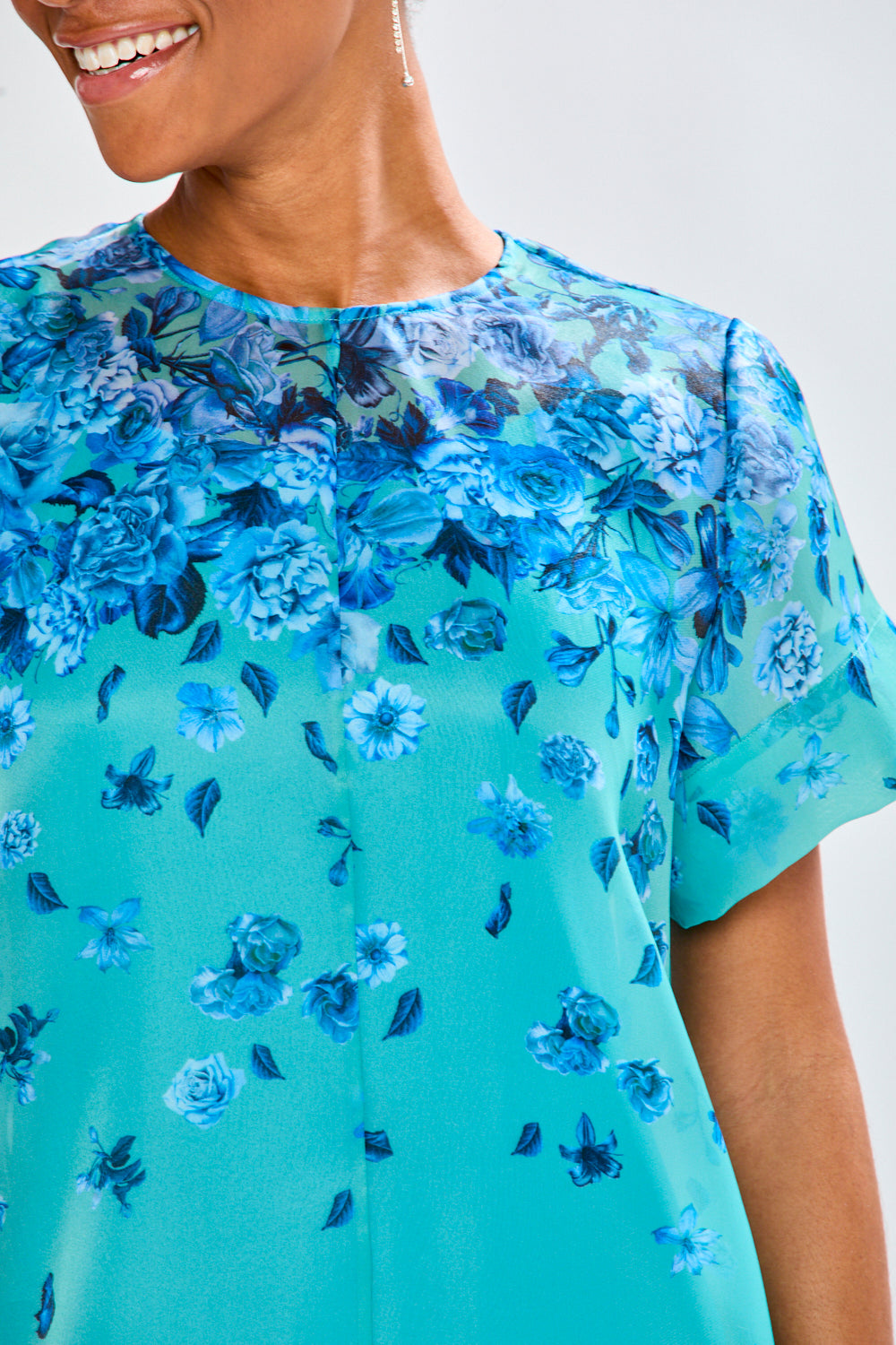 Woman wearing a blue floral dress against a white background