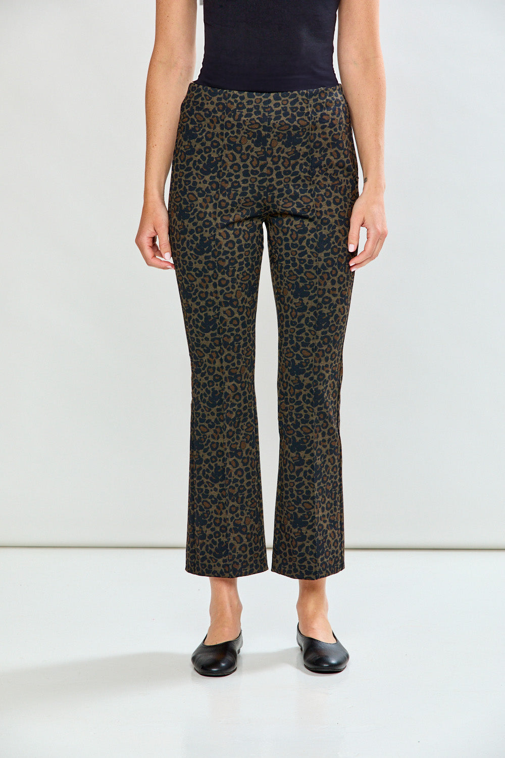 Woman wearing leopard print pants on a plain background