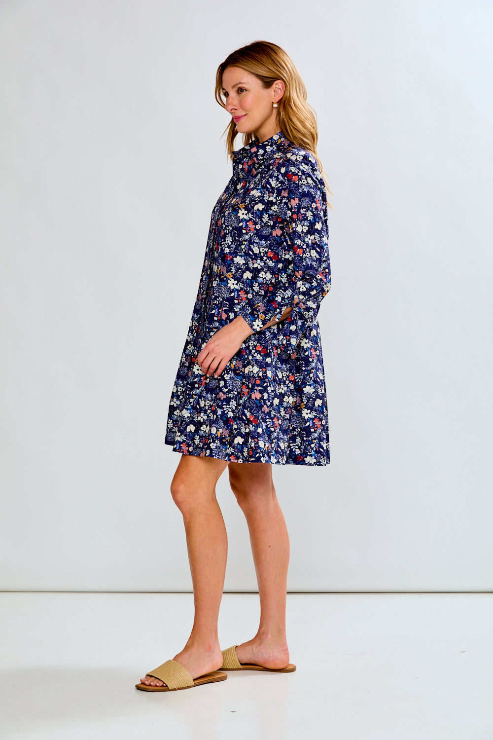 Woman wearing a blue floral dress against a white background