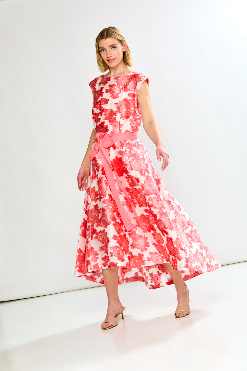 Woman wearing a pink and white floral dress on a white background