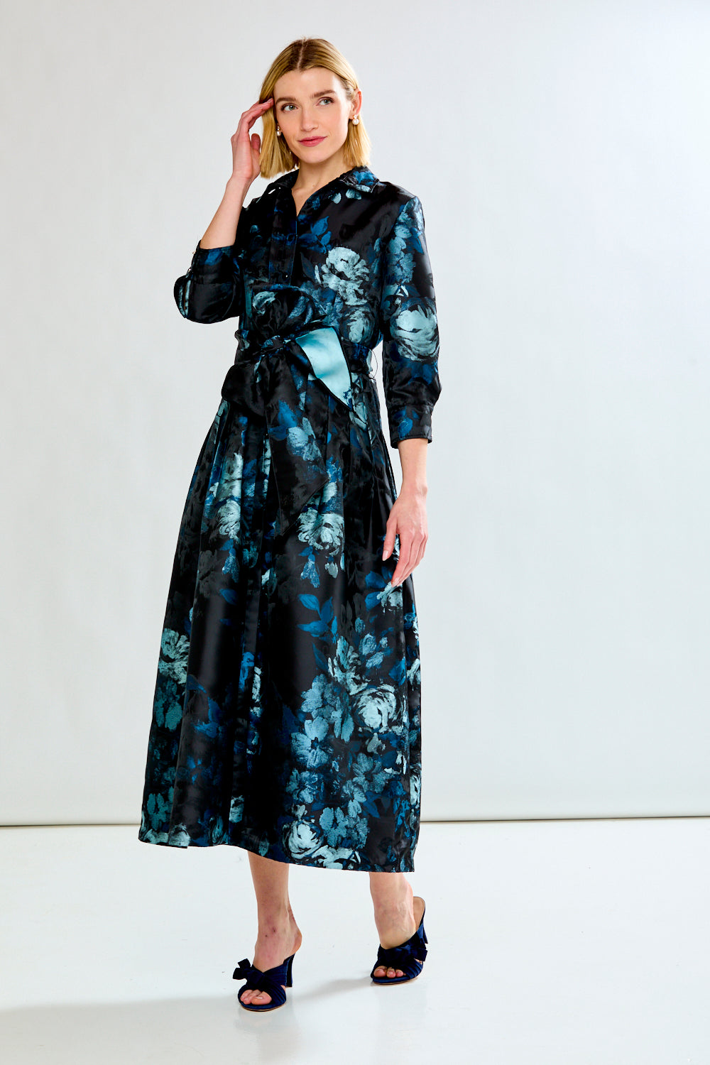 Woman wearing a black floral dress against a white background