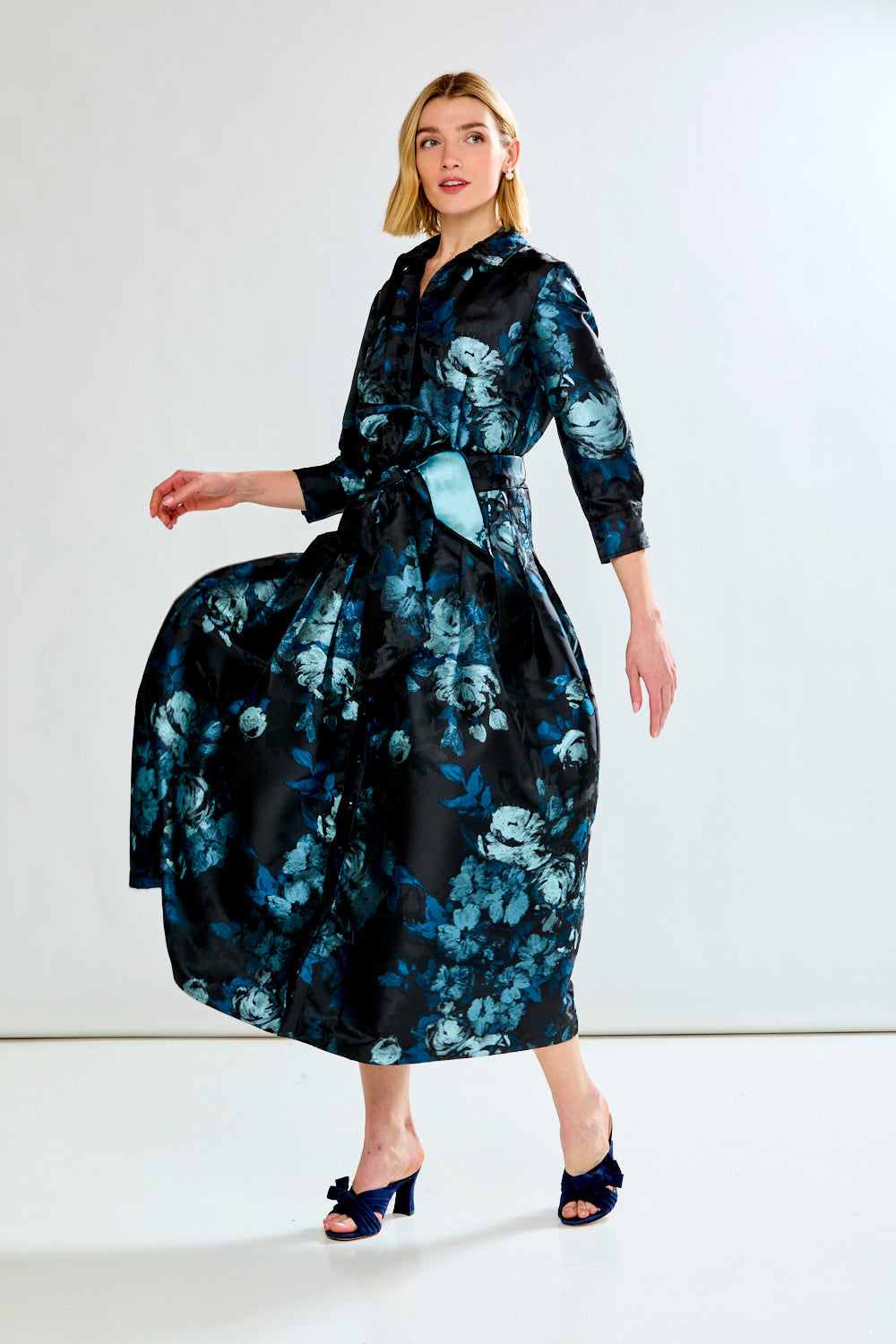 Woman wearing a black floral dress on a white background