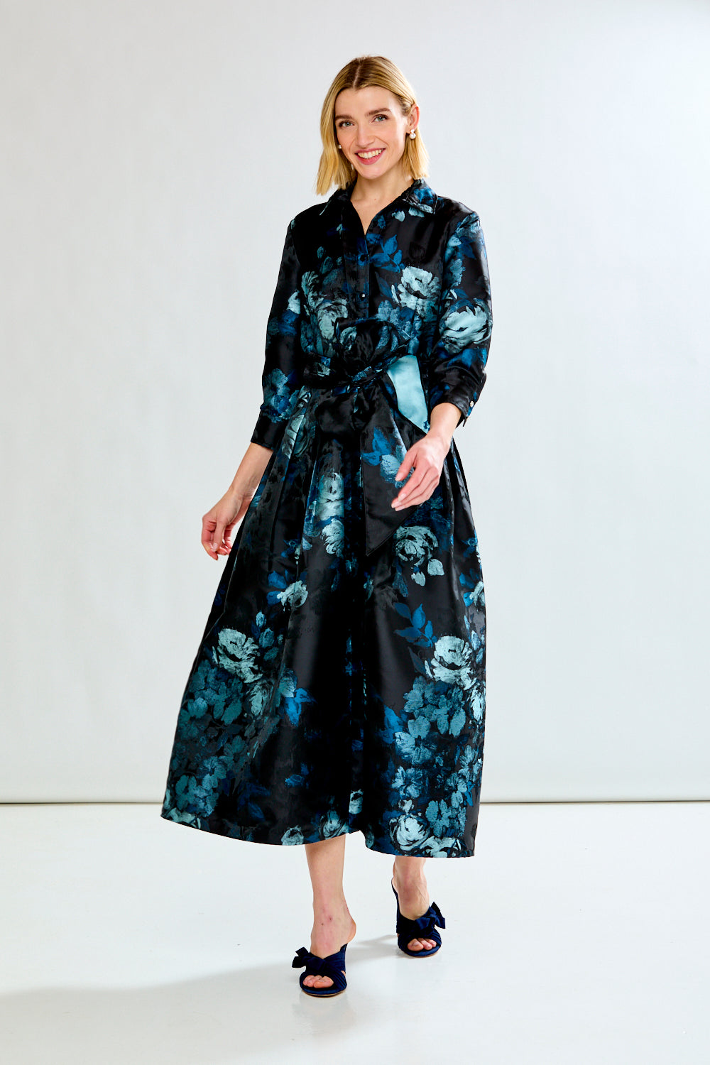 Woman wearing a black floral dress against a white background