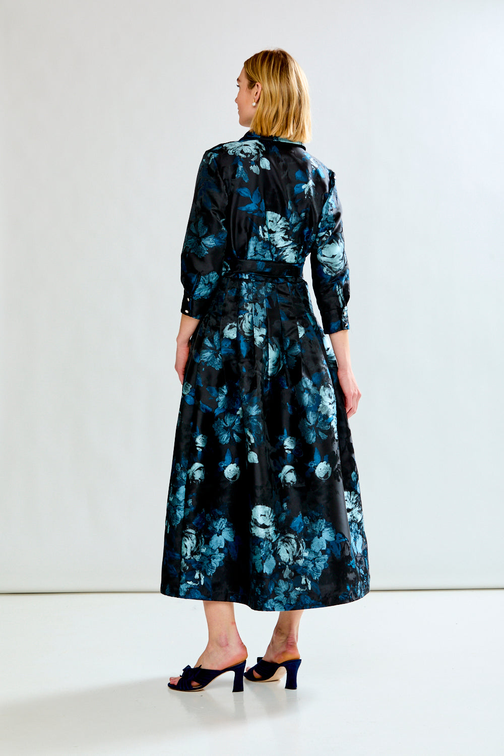 Woman wearing a black floral dress against a white background