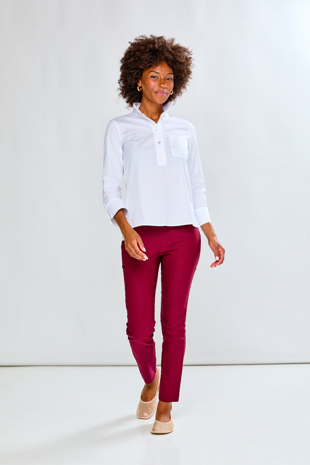 Person wearing a white shirt and red pants on a white background