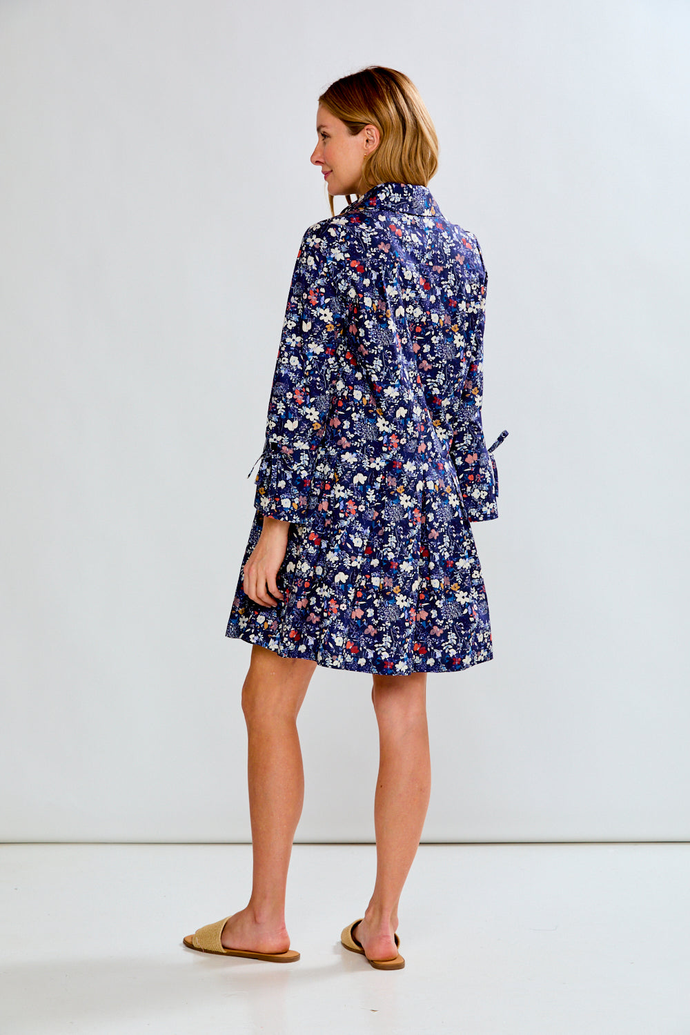 Woman wearing a blue floral dress against a white background