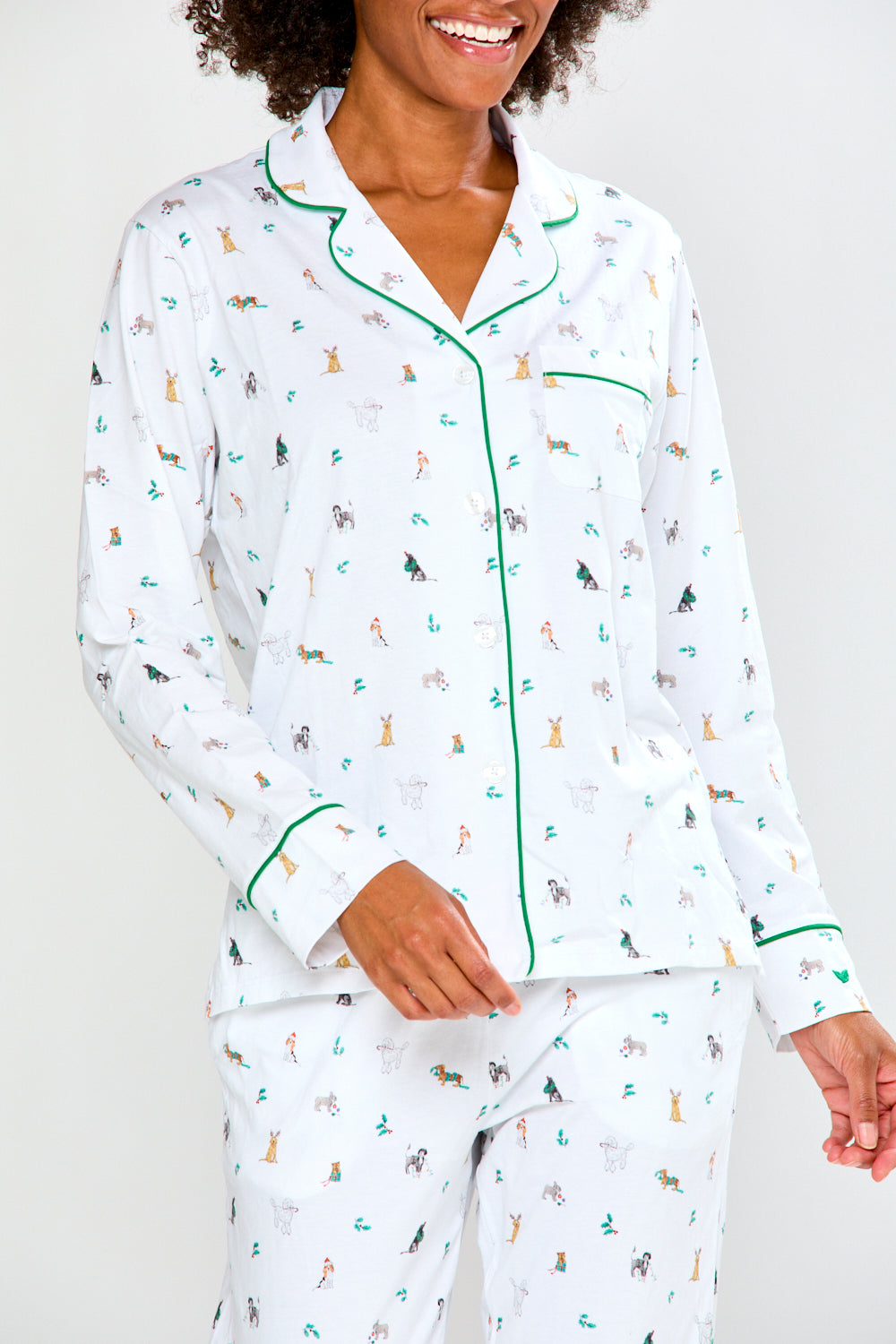 Woman wearing a white pajama set with a dog pattern on a white background