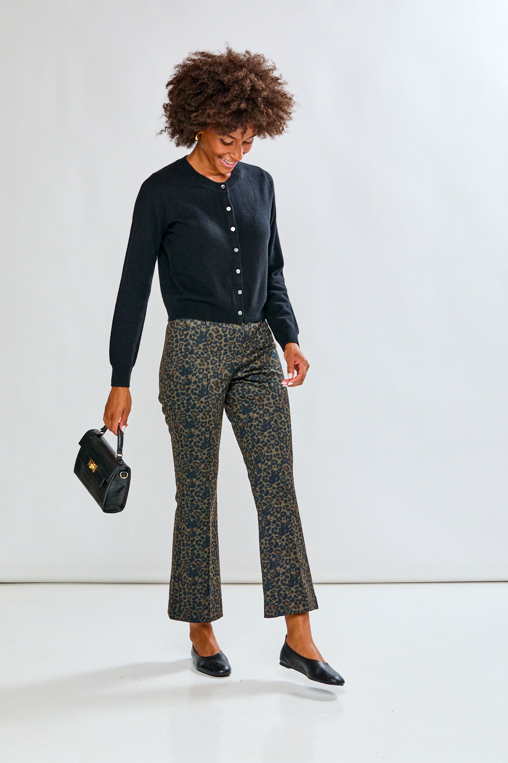 Woman wearing leopard print pants and a black sweater