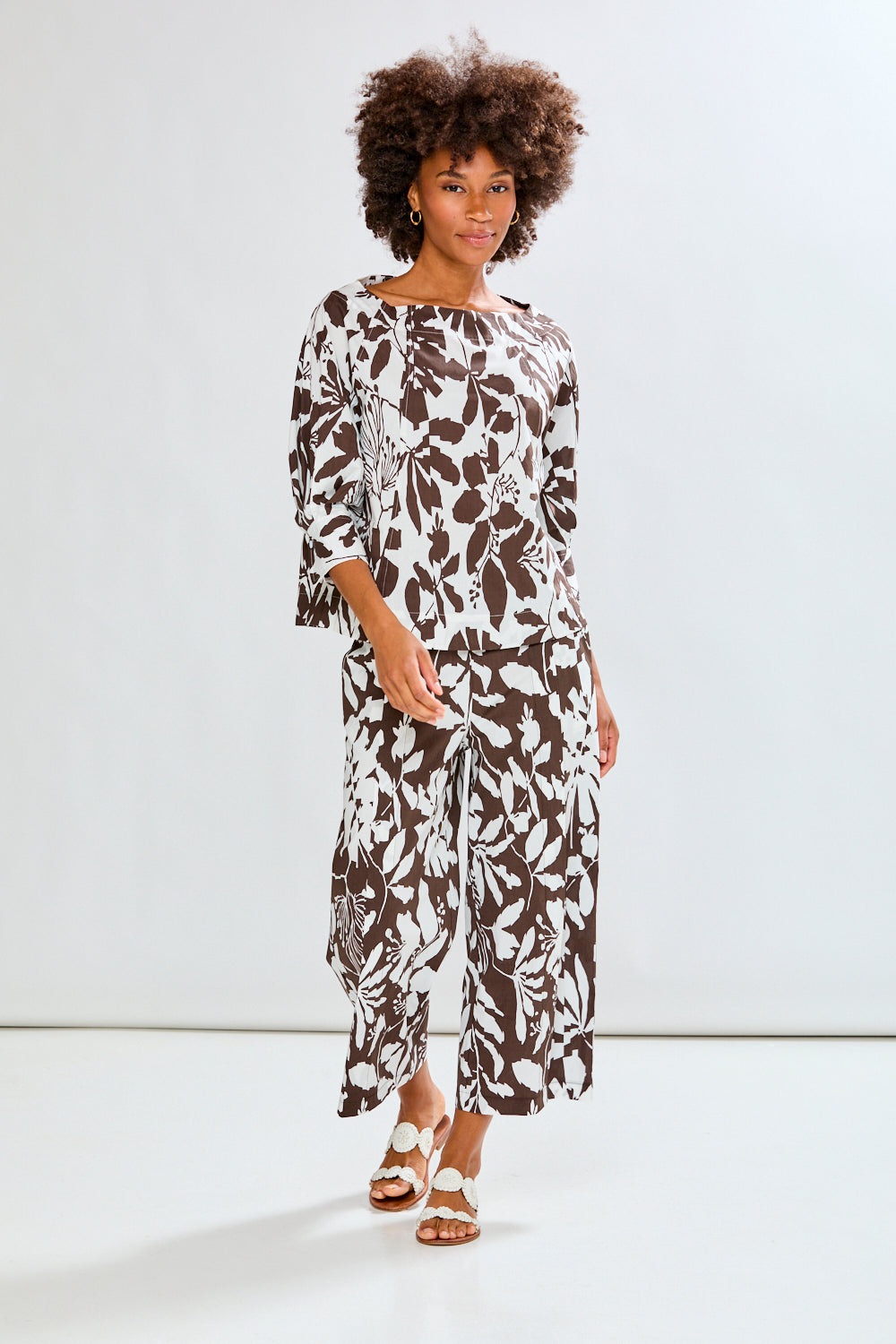 Woman wearing a patterned top on a white background