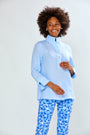 Person wearing a light blue top and blue floral pants on a white background