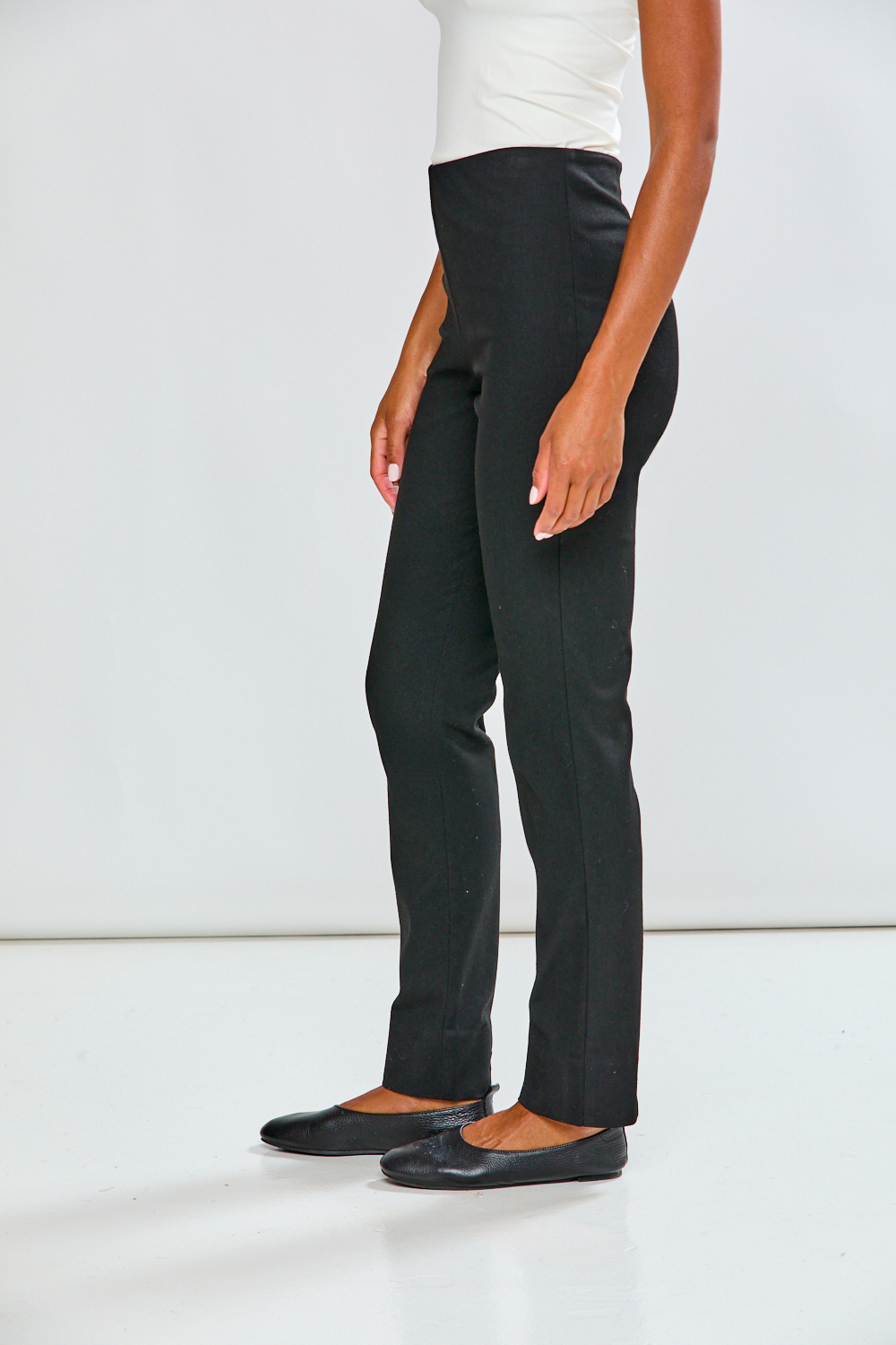 Person wearing black pants on a white background