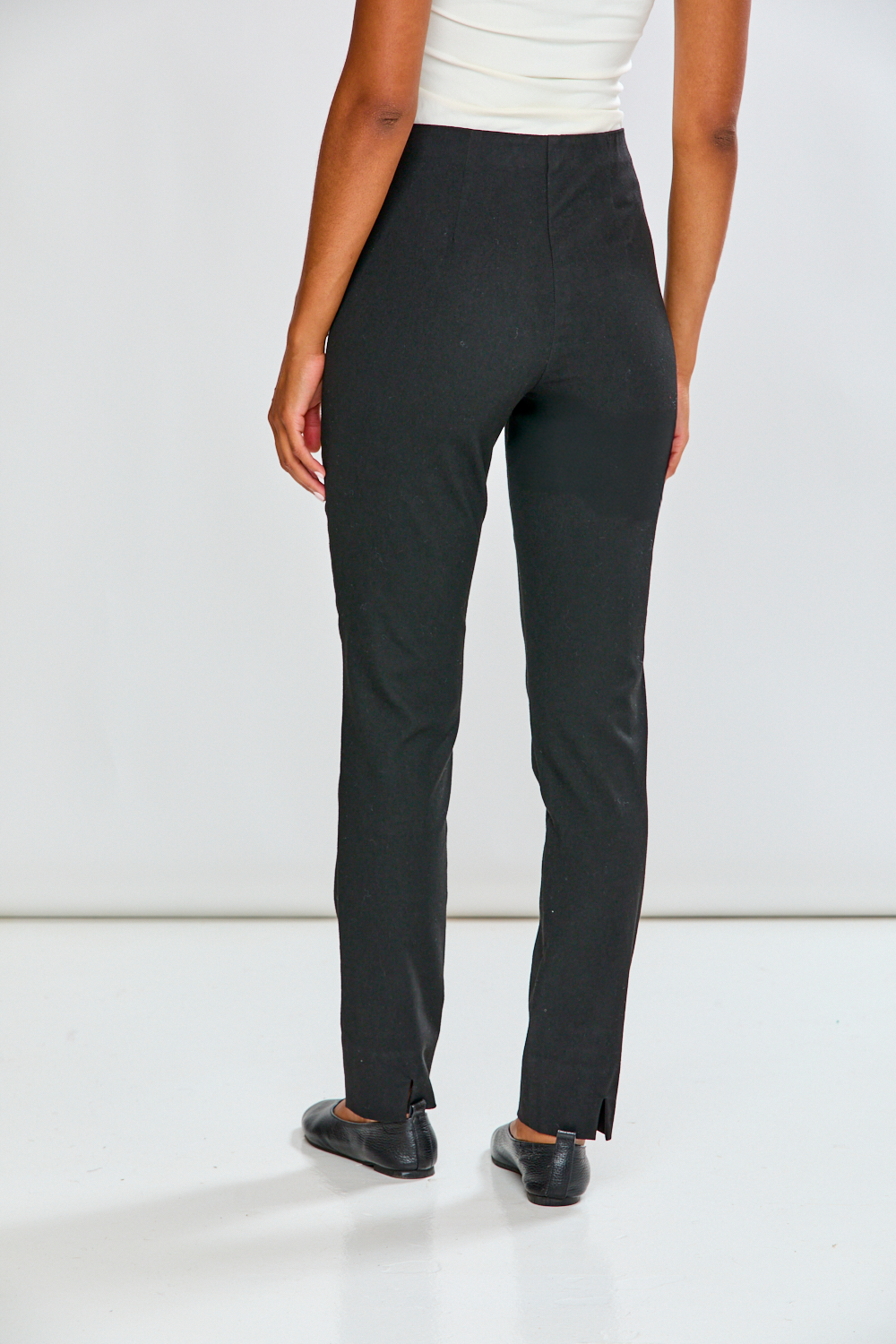 Person wearing black pants on a white background