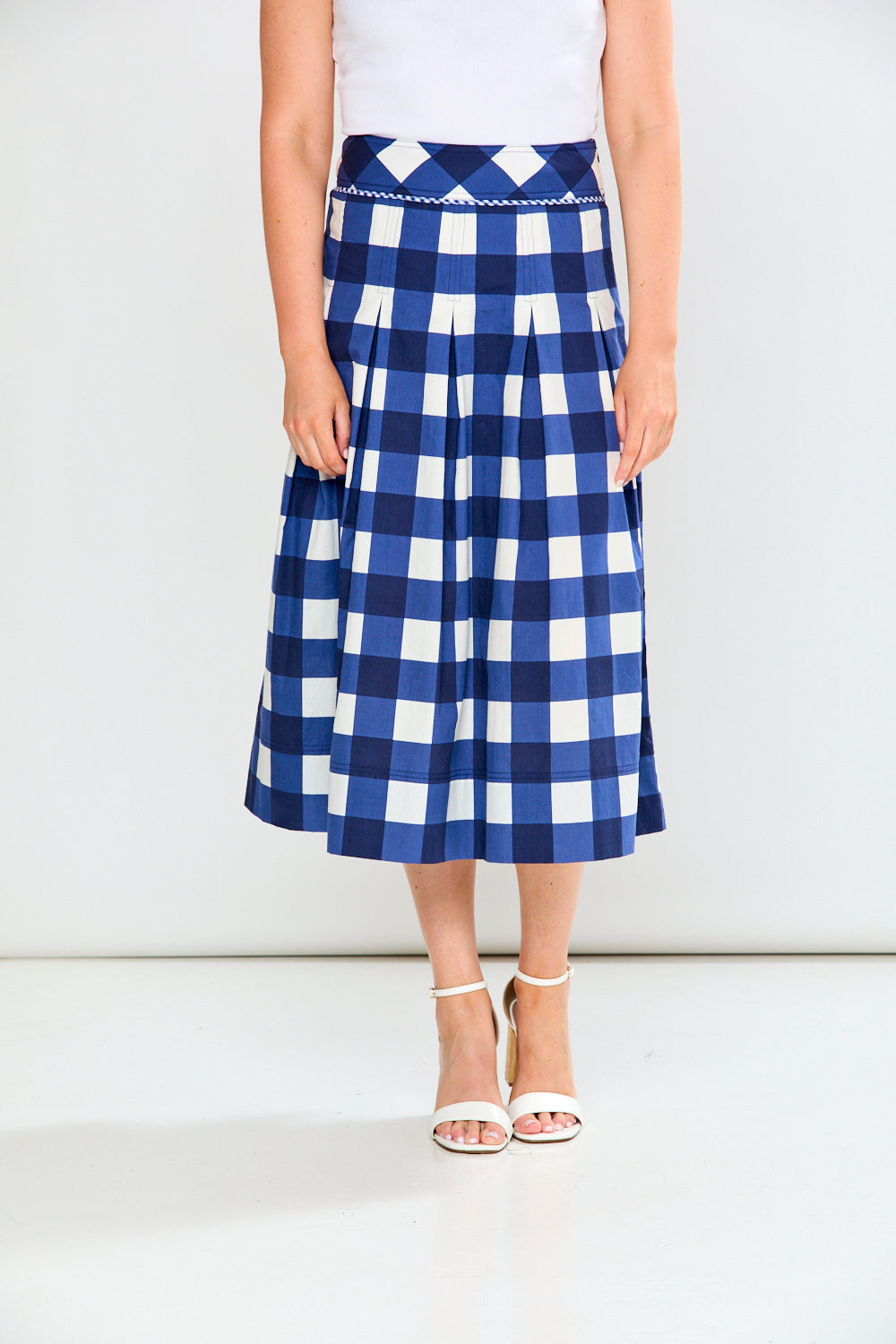 Person wearing a blue and white checkered skirt on a white background