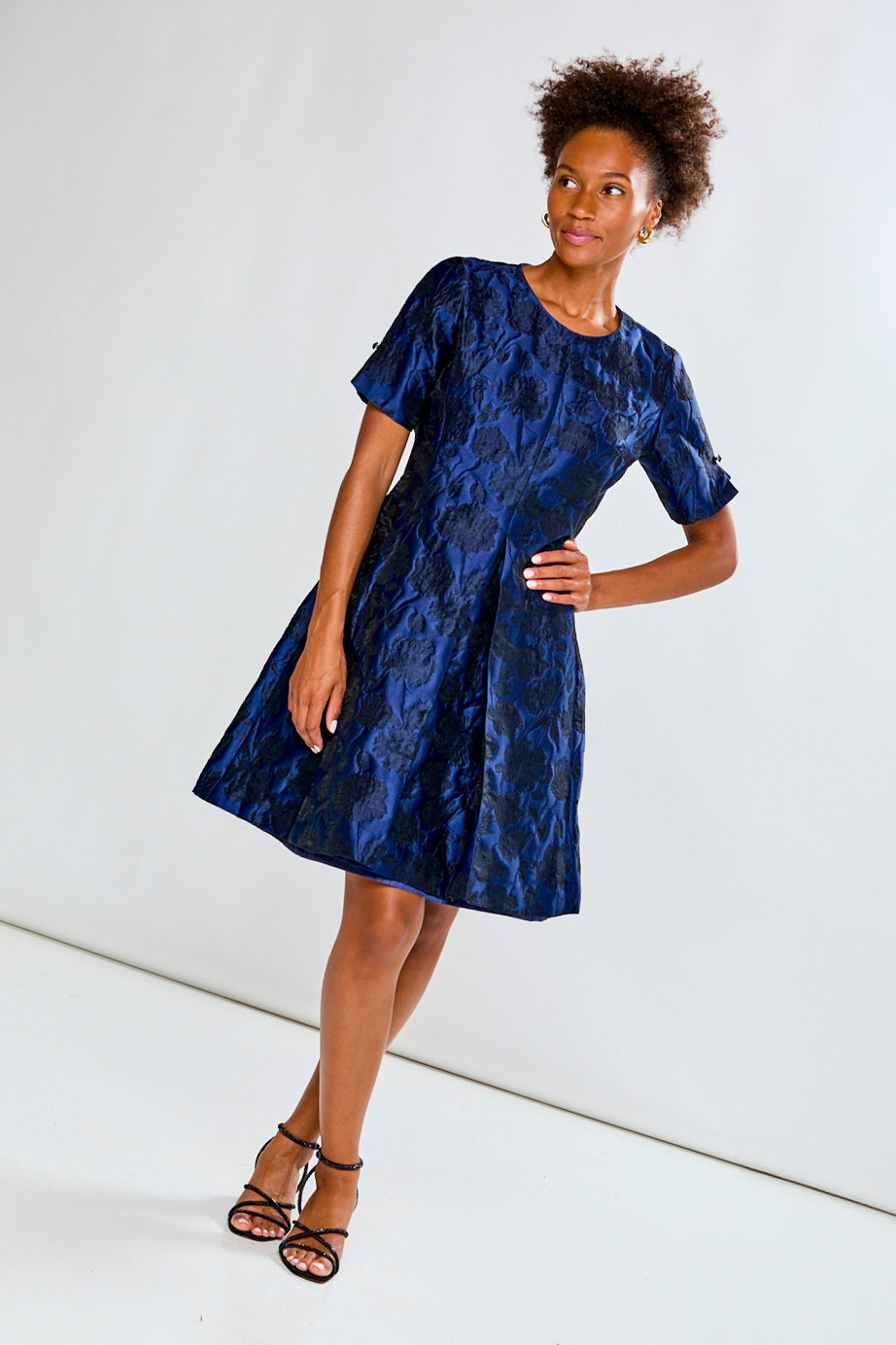 Woman wearing a blue patterned dress against a white background