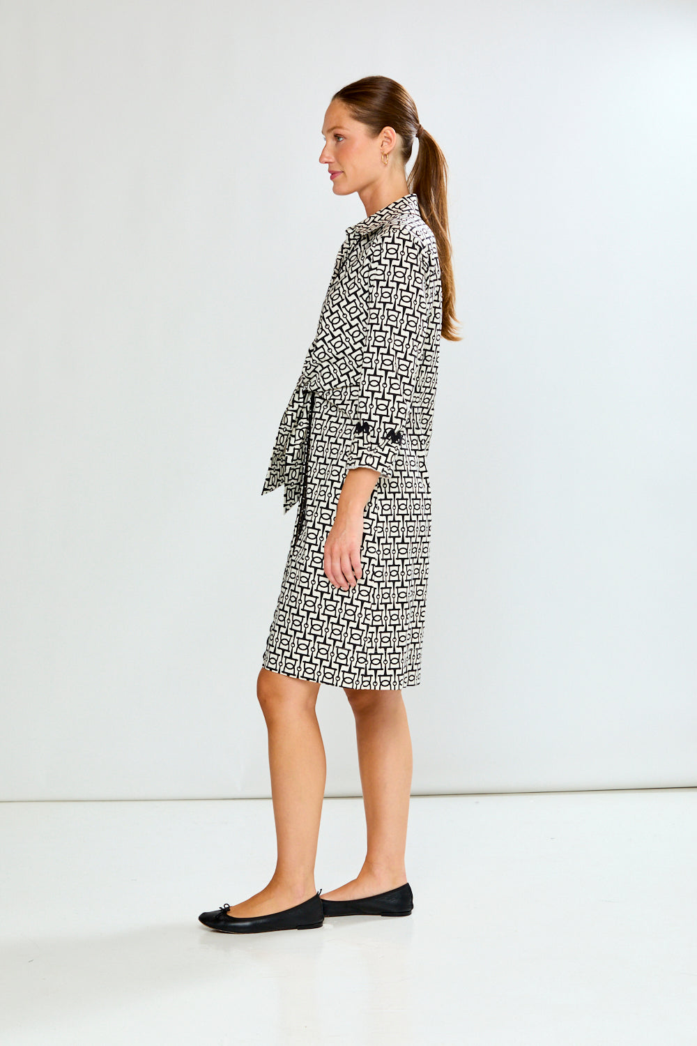 Woman wearing a black and white patterned dress on a white background
