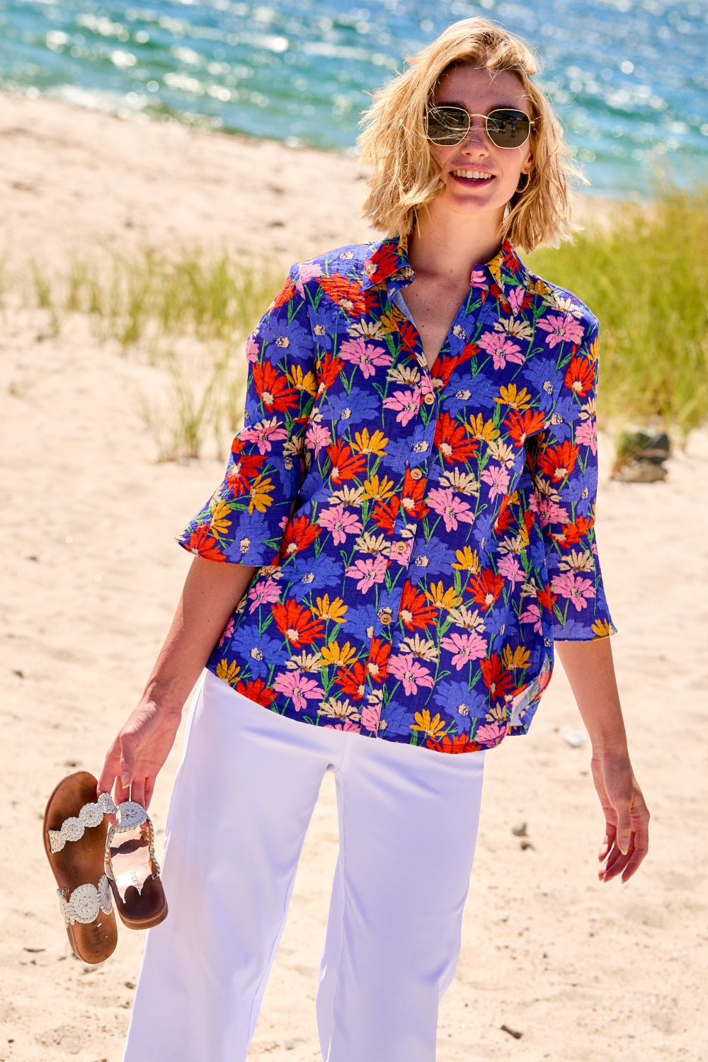 Woman wearing a colorful floral shirt on a beach
