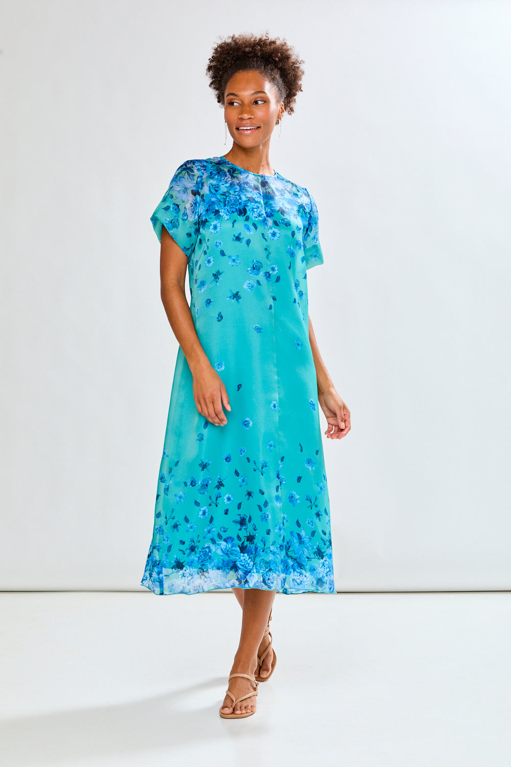 Woman wearing a blue floral dress against a white background