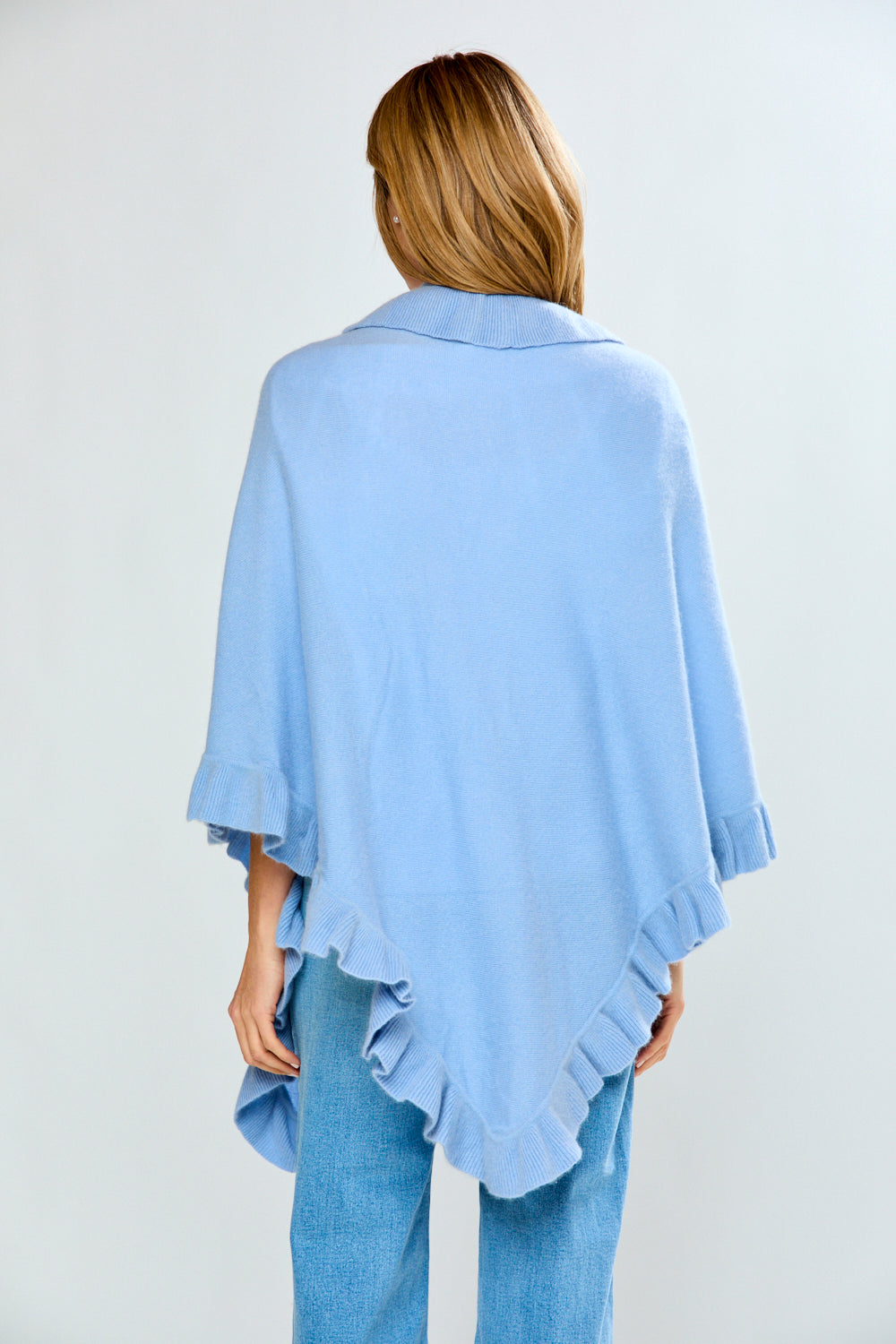 Light blue poncho worn by a person on a plain background