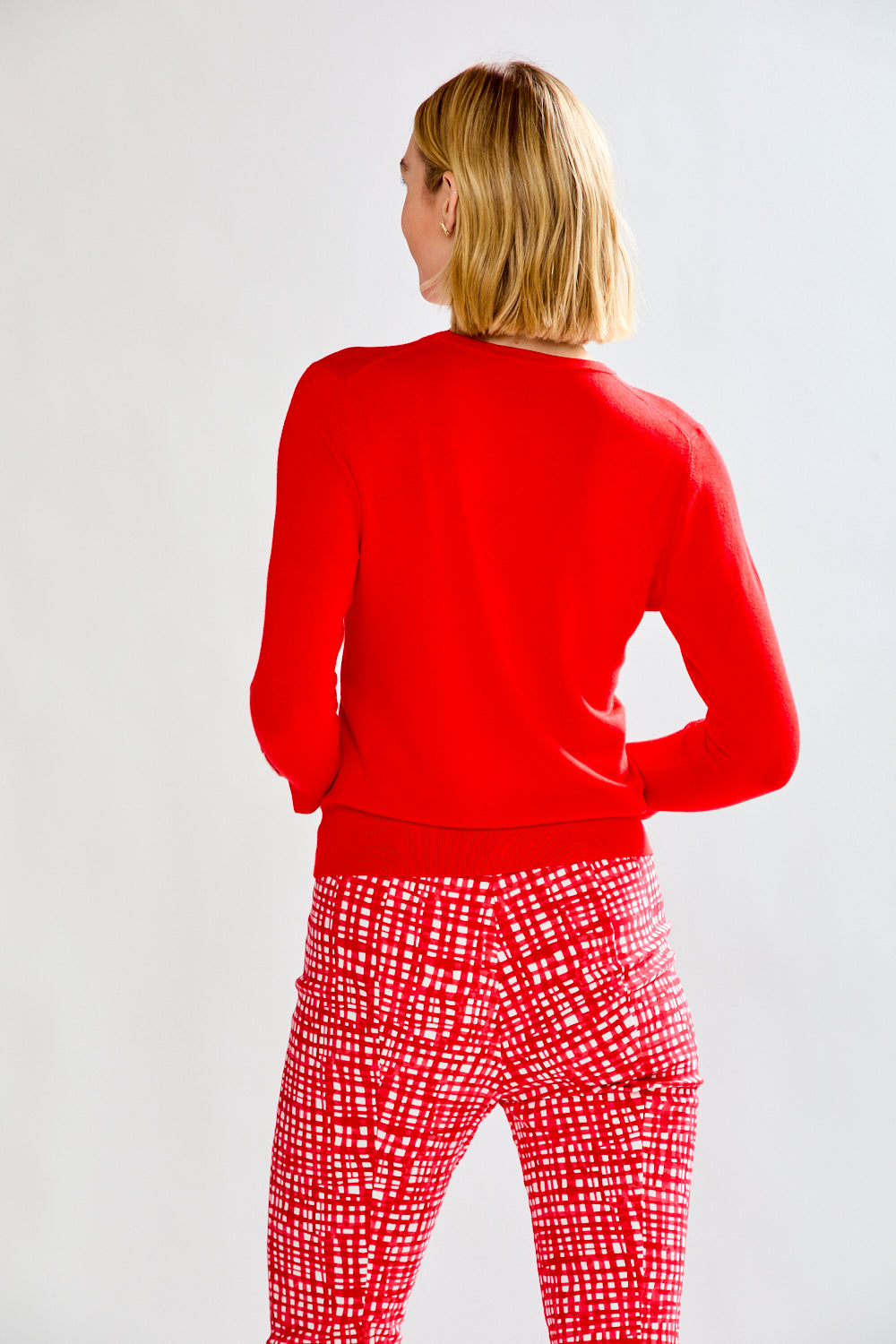 woman in red sweater and patterned pants