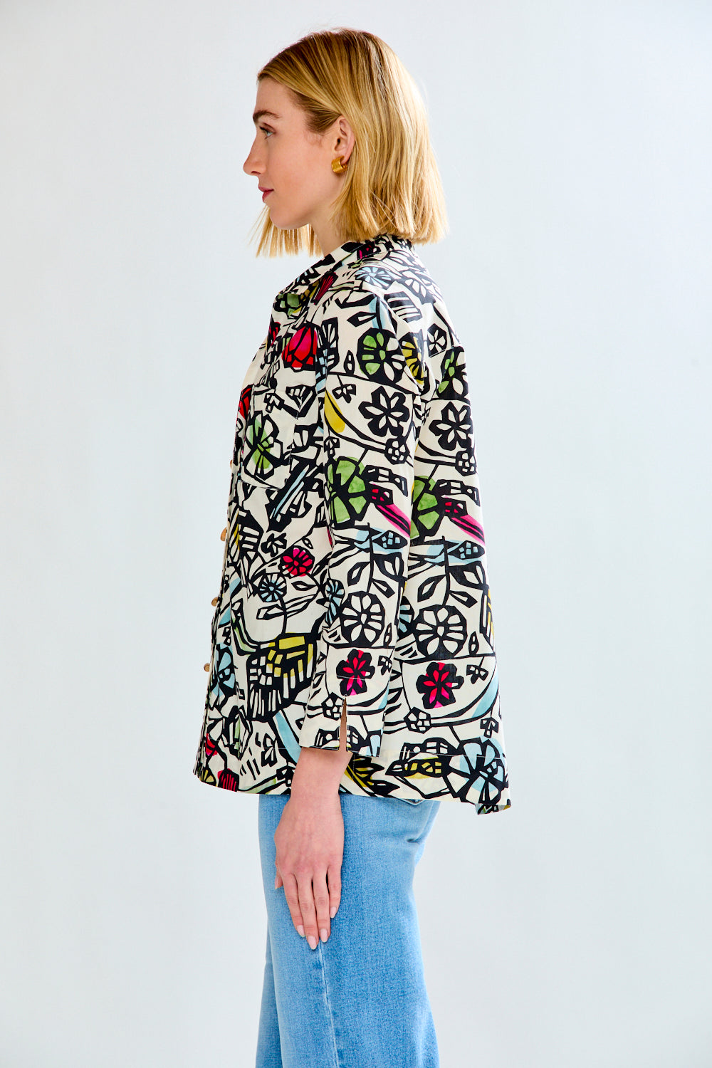 Woman wearing a colorful patterned shirt with a white background