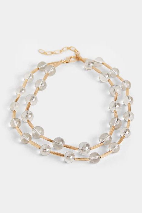 Beaded necklace with gold accents on a light gray background