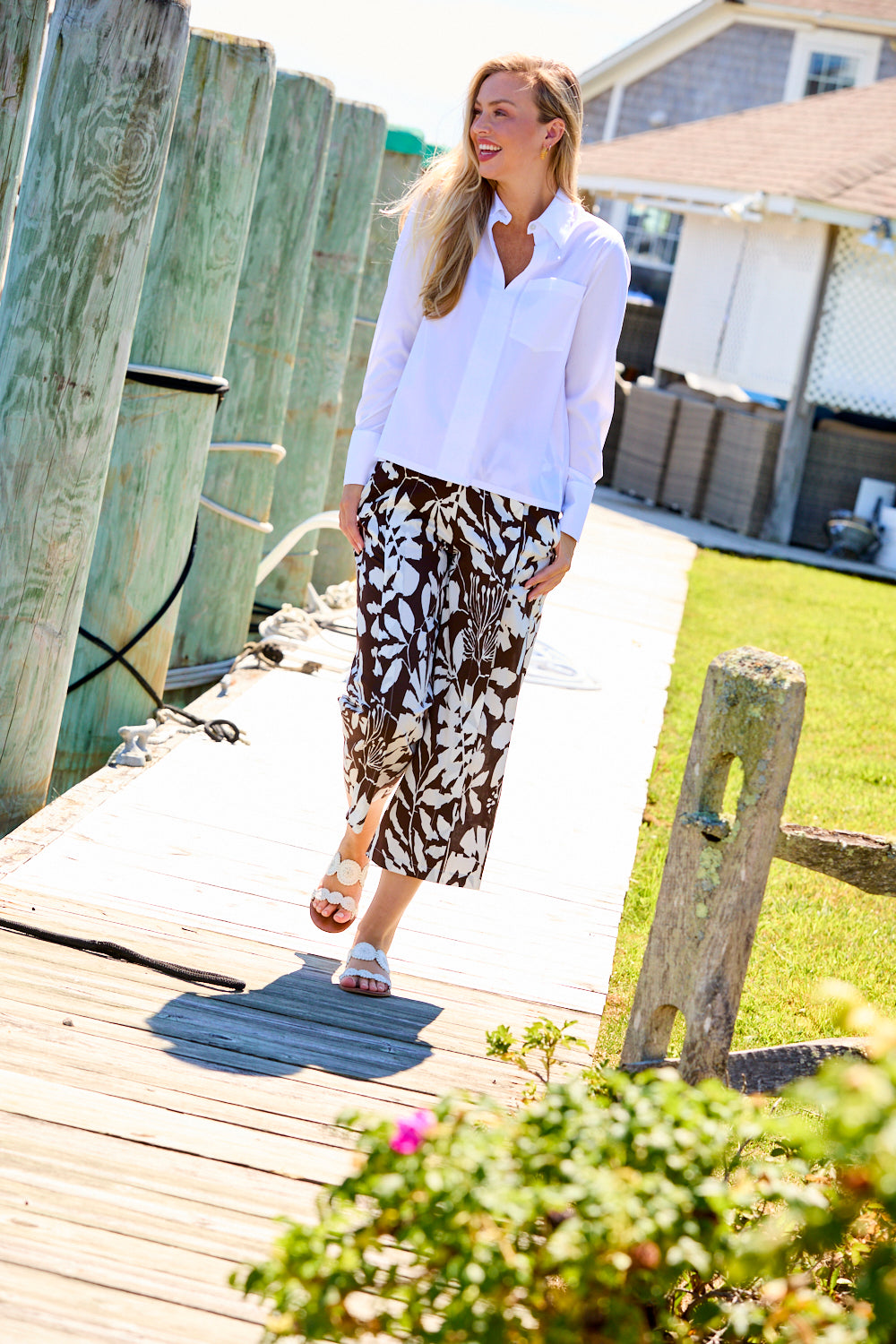 Woman wearing a white blouse and patterned pants 